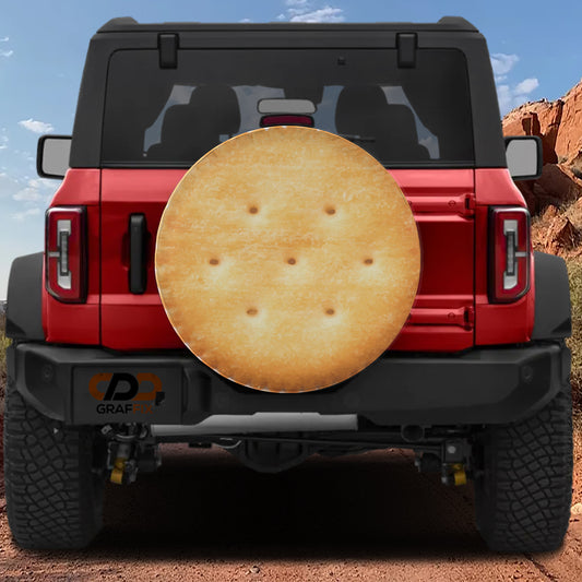 a red Jeep Wrangler with a large circular object resembling a cracker or cookie attached to the rear of the vehicle.