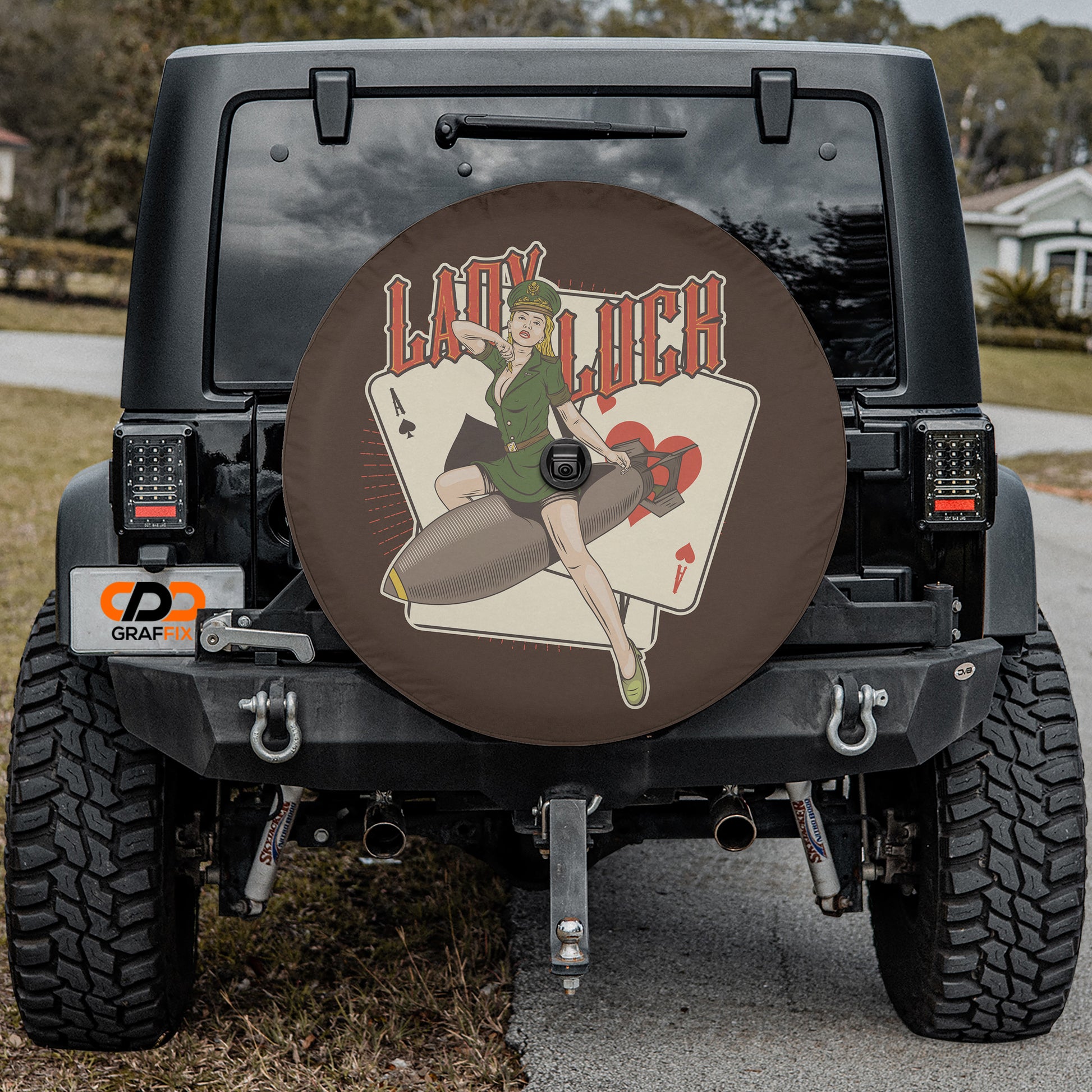 the back of a black Jeep Wrangler with a wheel cover featuring a lady and a playing card design.