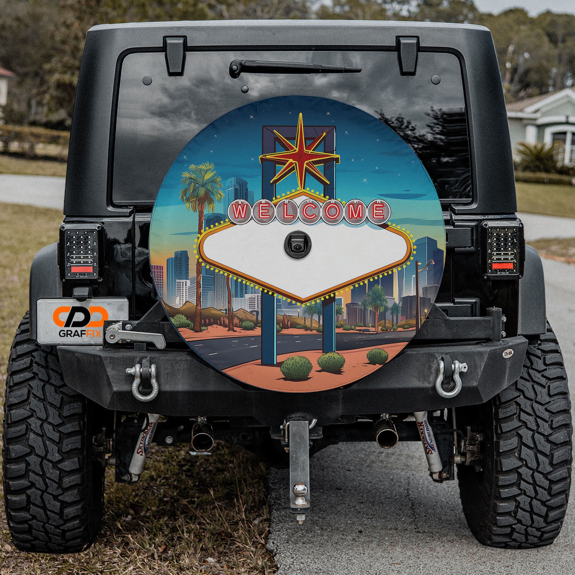 a black Jeep Wrangler with a large, colorful wheel cover depicting a Las Vegas-style sign.