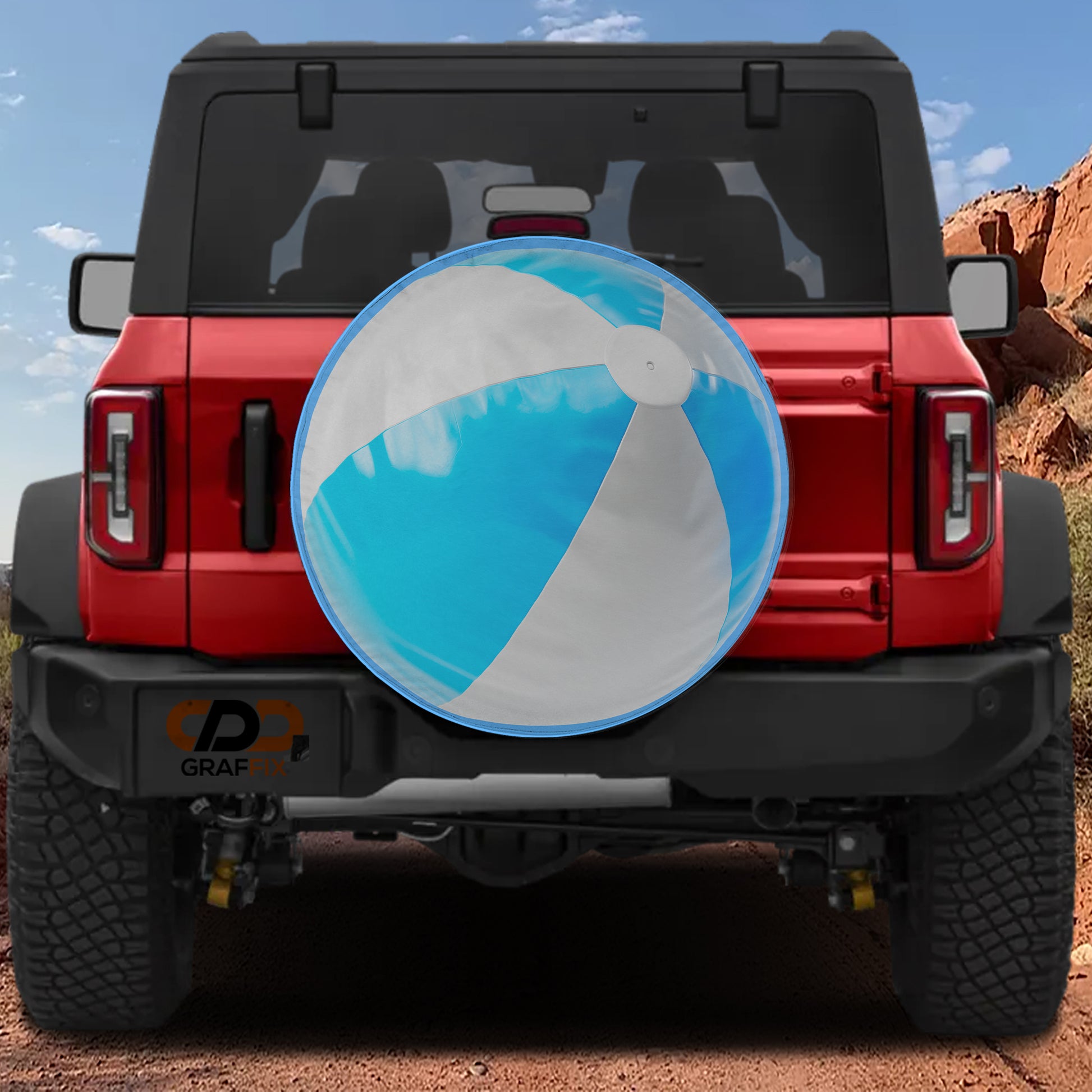 A red Jeep Wrangler with a large blue and white beach ball attached to the rear bumper.