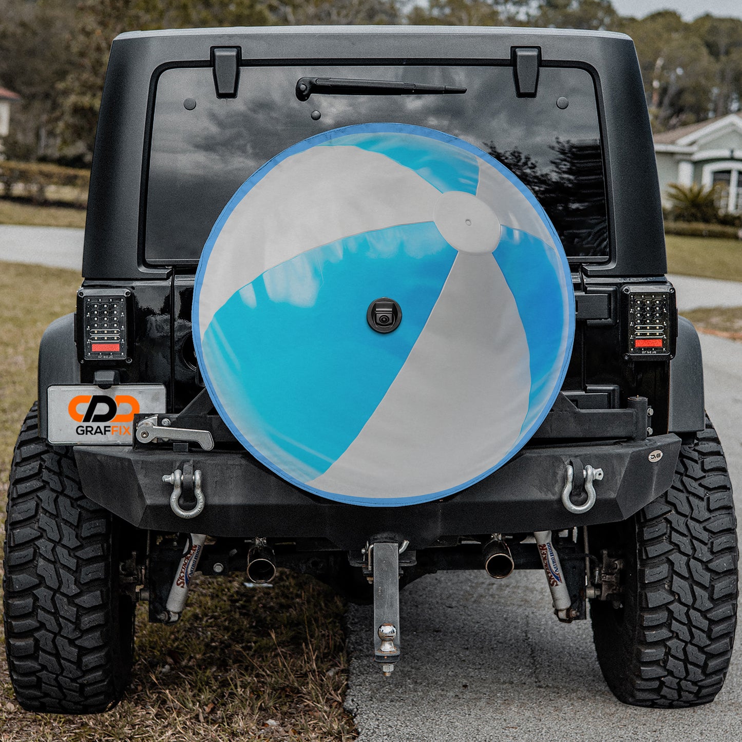 a black Jeep Wrangler with a large blue and white beach ball attached to the rear of the vehicle.