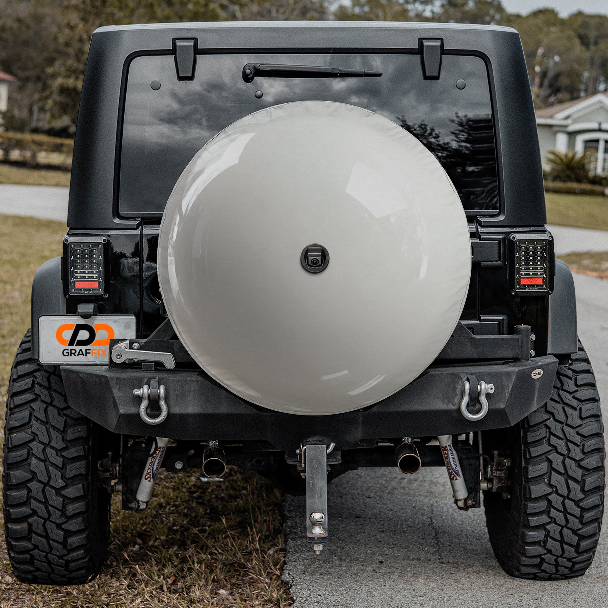 a black Jeep Wrangler with a large white satellite dish attached to the rear of the vehicle.