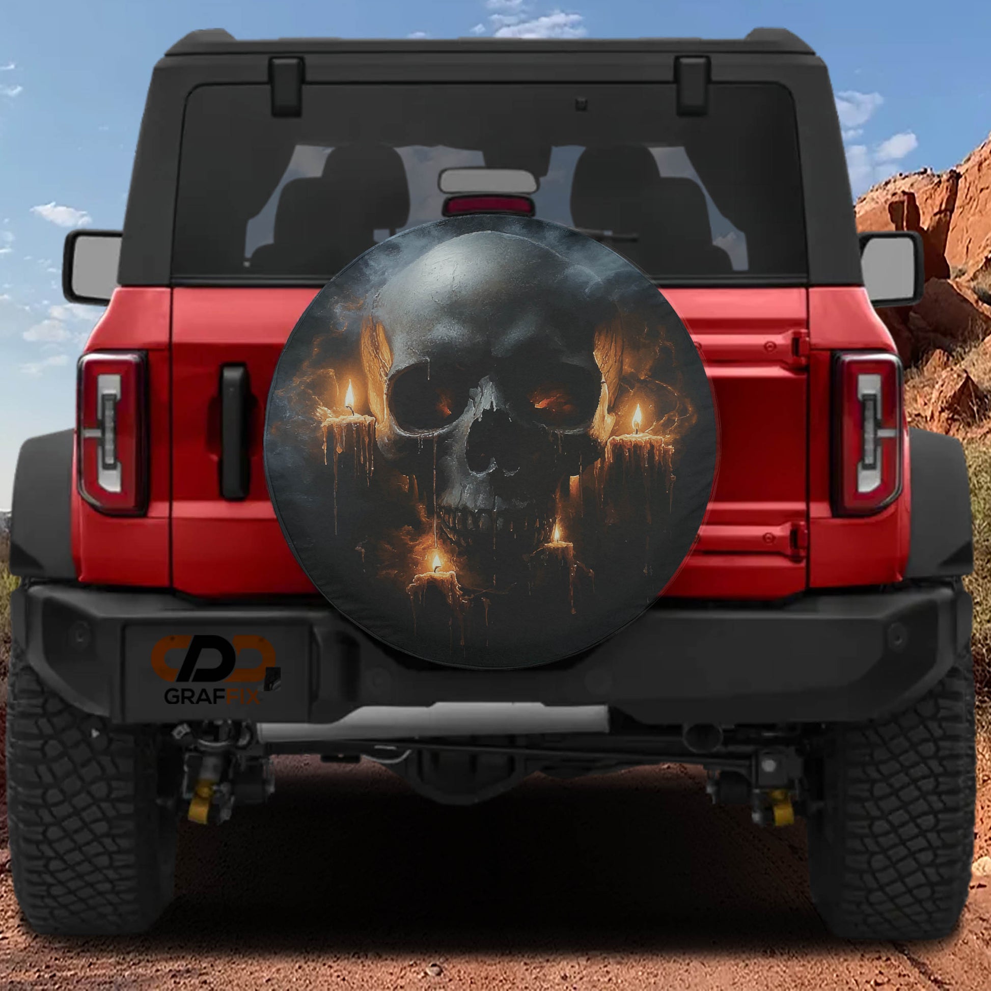 A red Jeep Wrangler with a skull-themed spare tire cover on the rear.