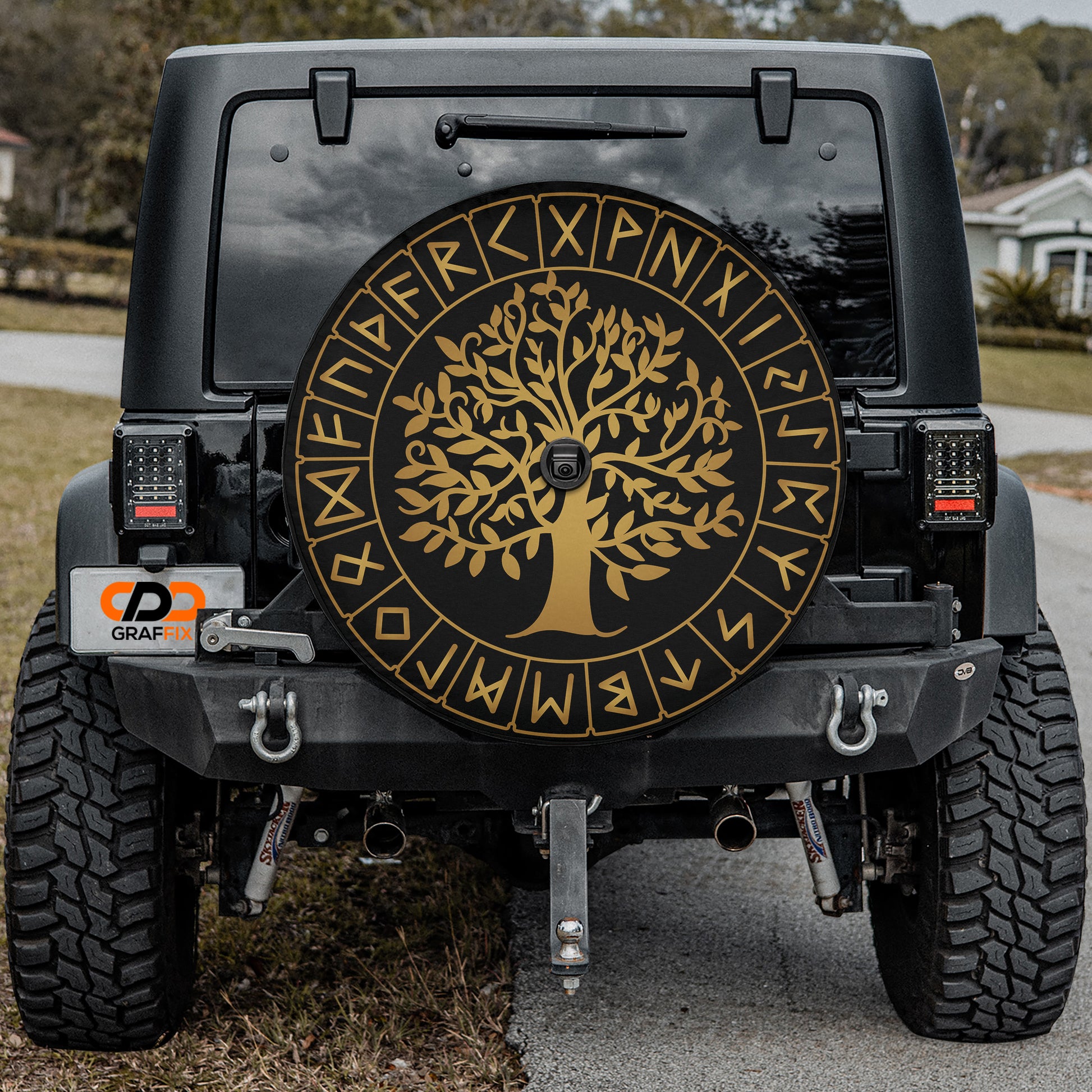 a black jeep with a gold tree of life emblem on it