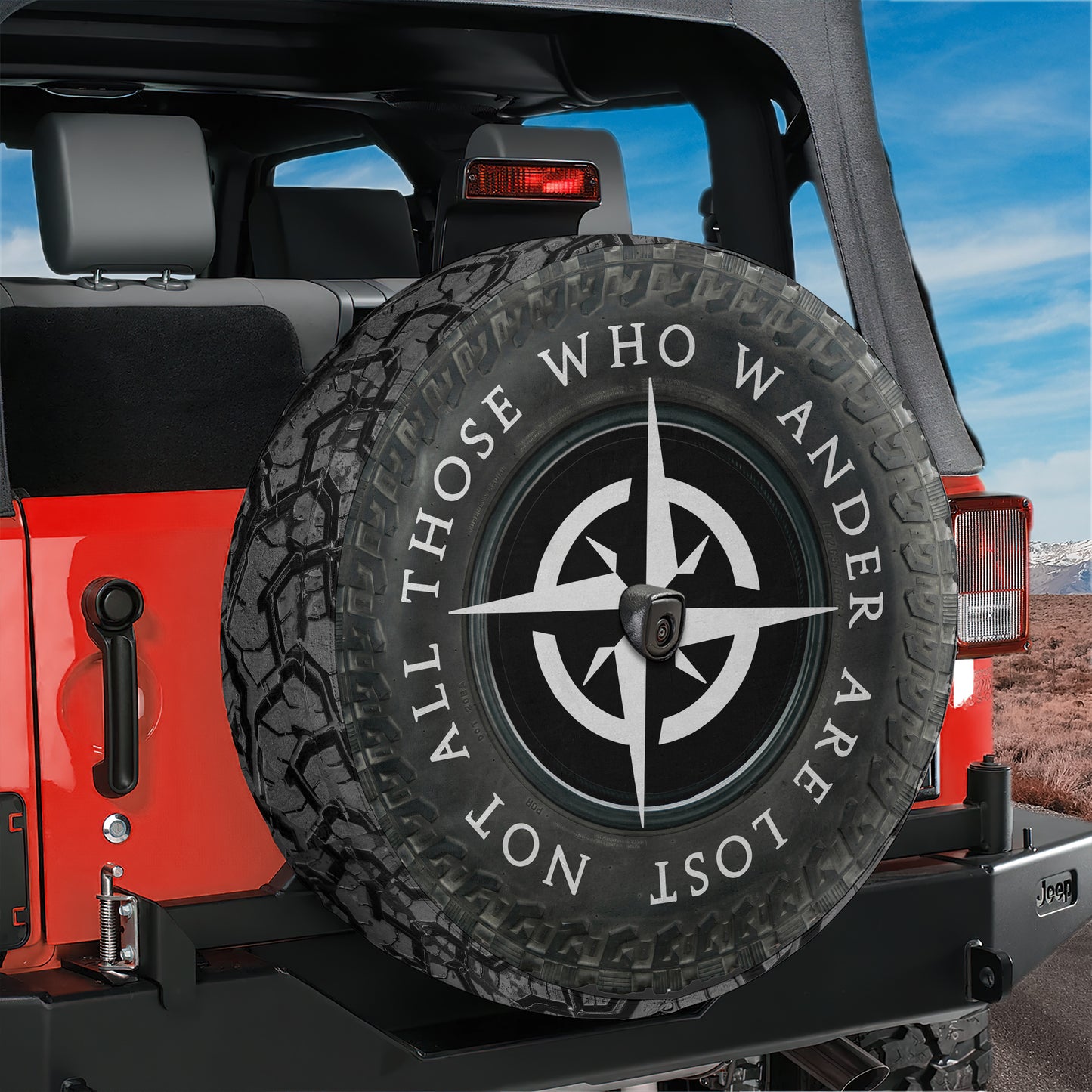 A red Jeep Wrangler with a spare tire attached, featuring a compass design on the tire.