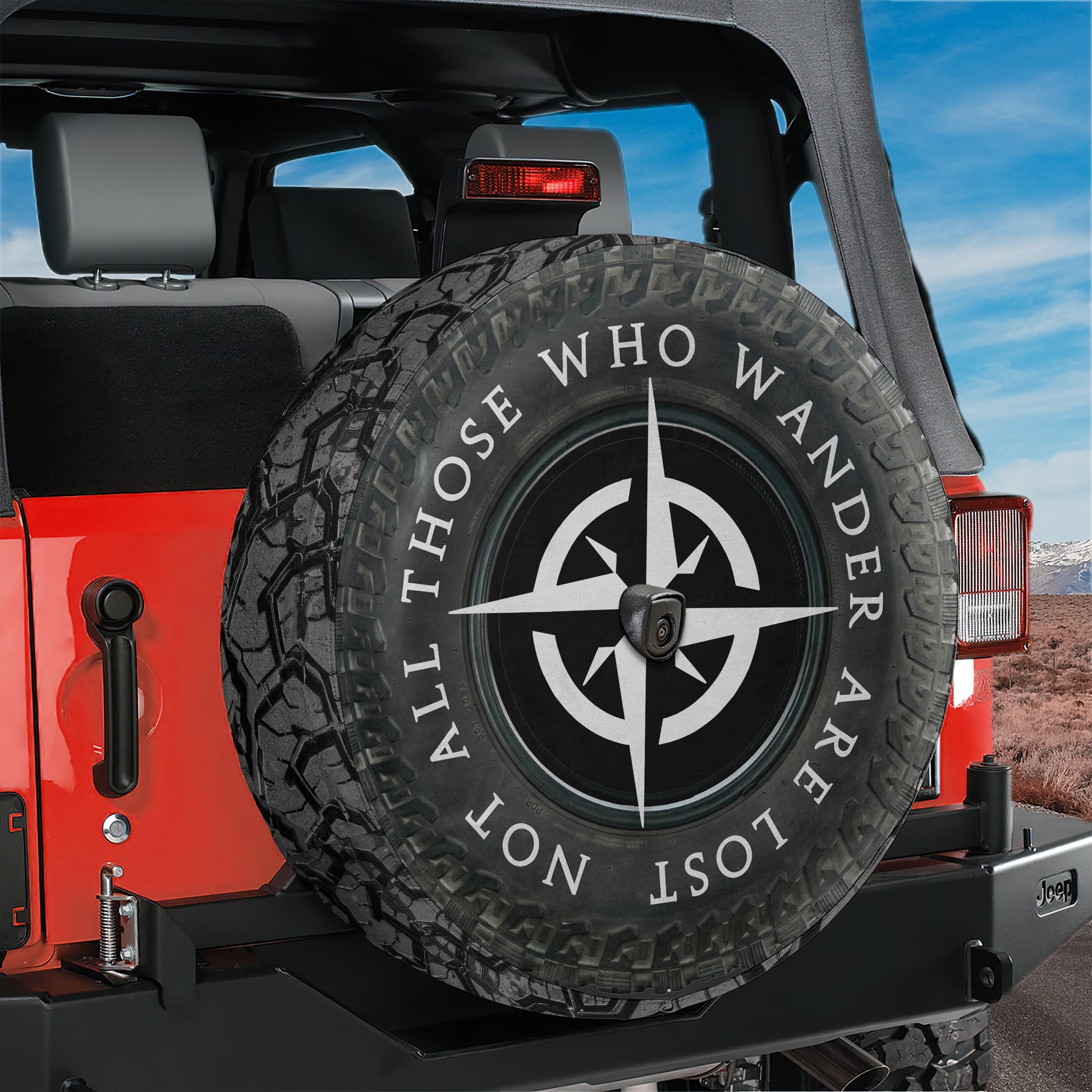 A red Jeep Wrangler with a spare tire attached, featuring a compass design on the tire.