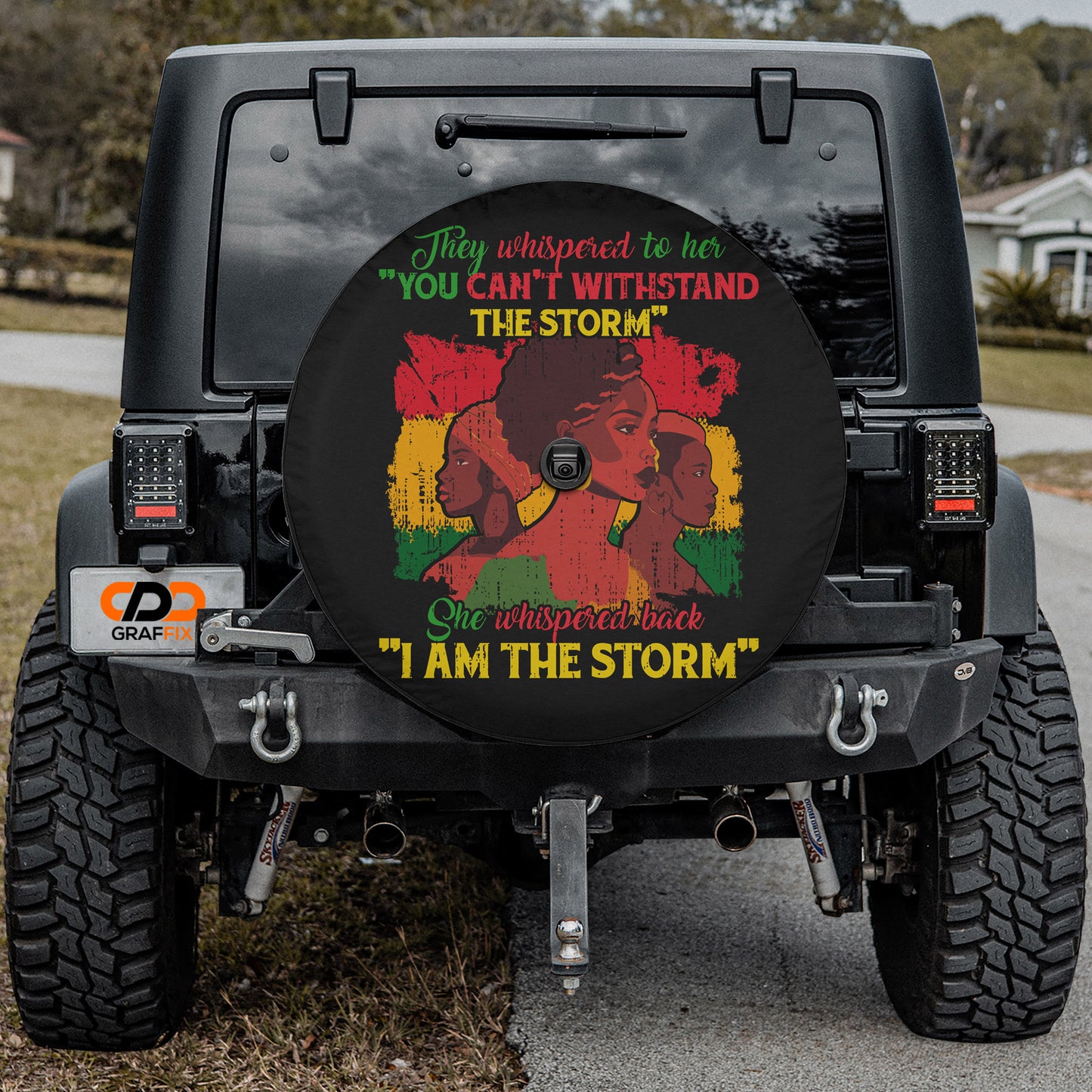 a black Jeep Wrangler with a large rear wheel cover featuring a colorful graphic and text.