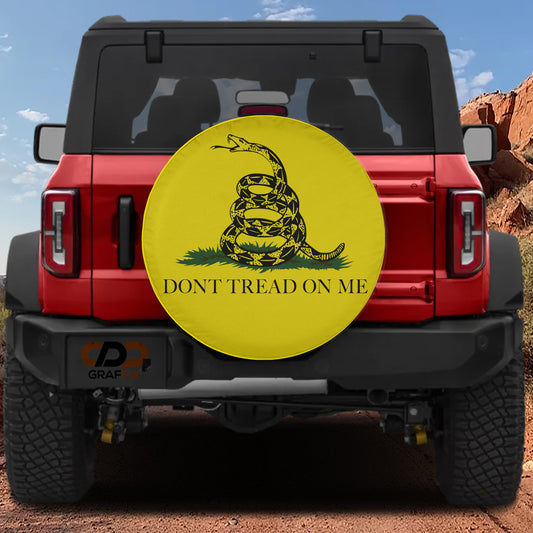 a red Jeep Wrangler with a large yellow wheel cover on the rear of the vehicle. The wheel cover displays a black and yellow design of a snake wrapped around the text "DON'T TREAD ON ME".
