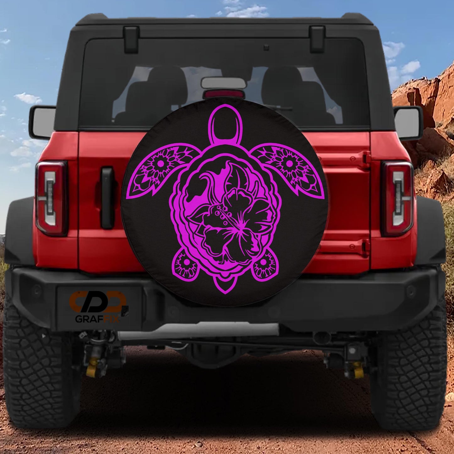A red Jeep Wrangler with a large turtle-shaped spare tire cover featuring a pink floral design.
