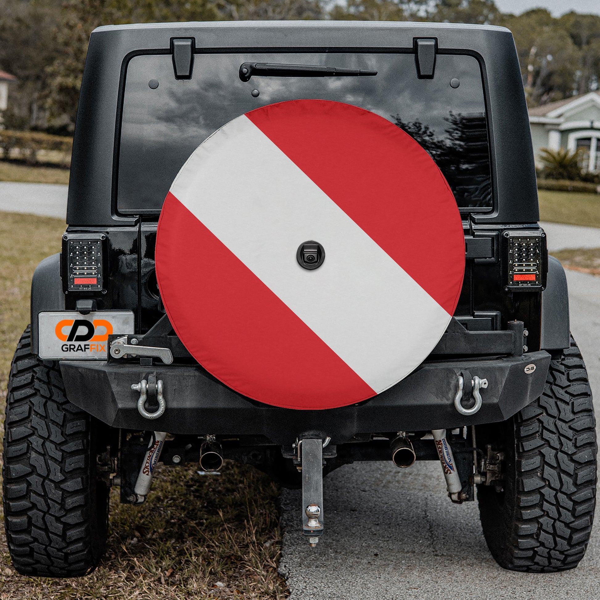 the rear of a black Jeep Wrangler with a large red and white tire cover attached to the vehicle.