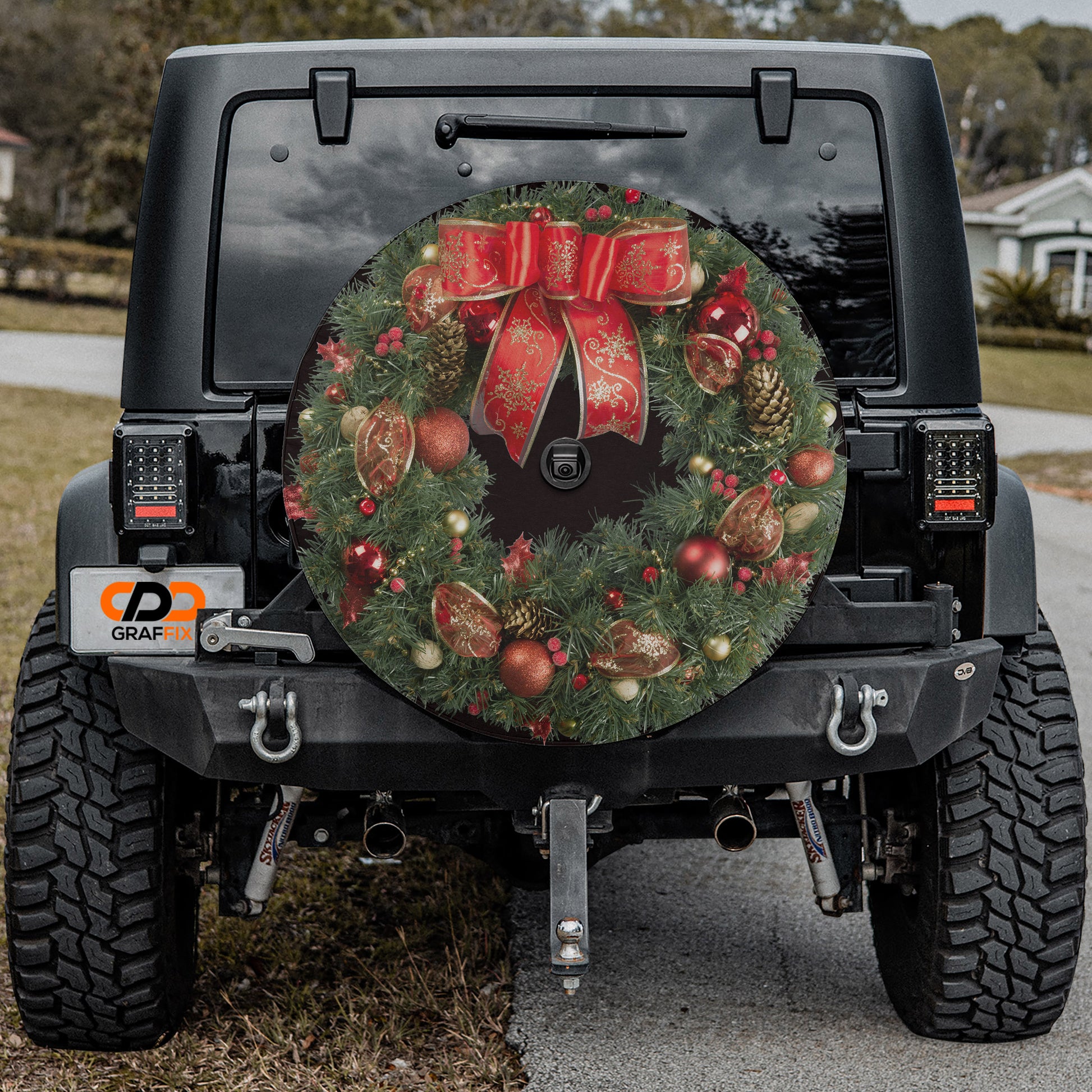 the back of a black Jeep Wrangler with a Christmas wreath decal on the rear window.