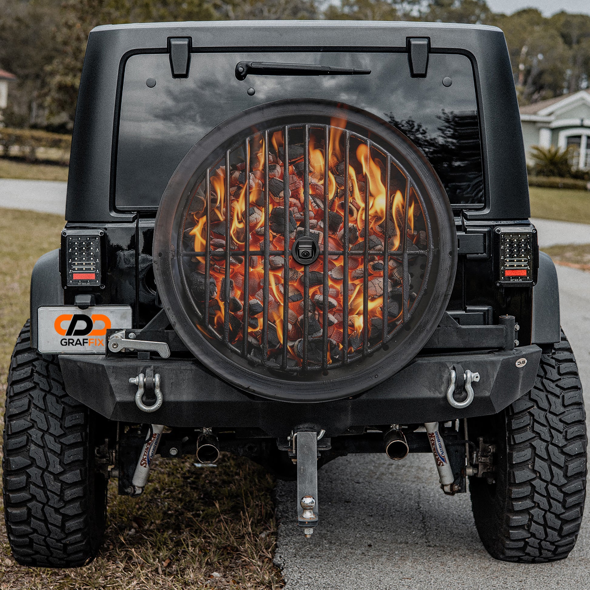 a black Jeep Wrangler with a large grill on the rear, which is filled with burning charcoal.