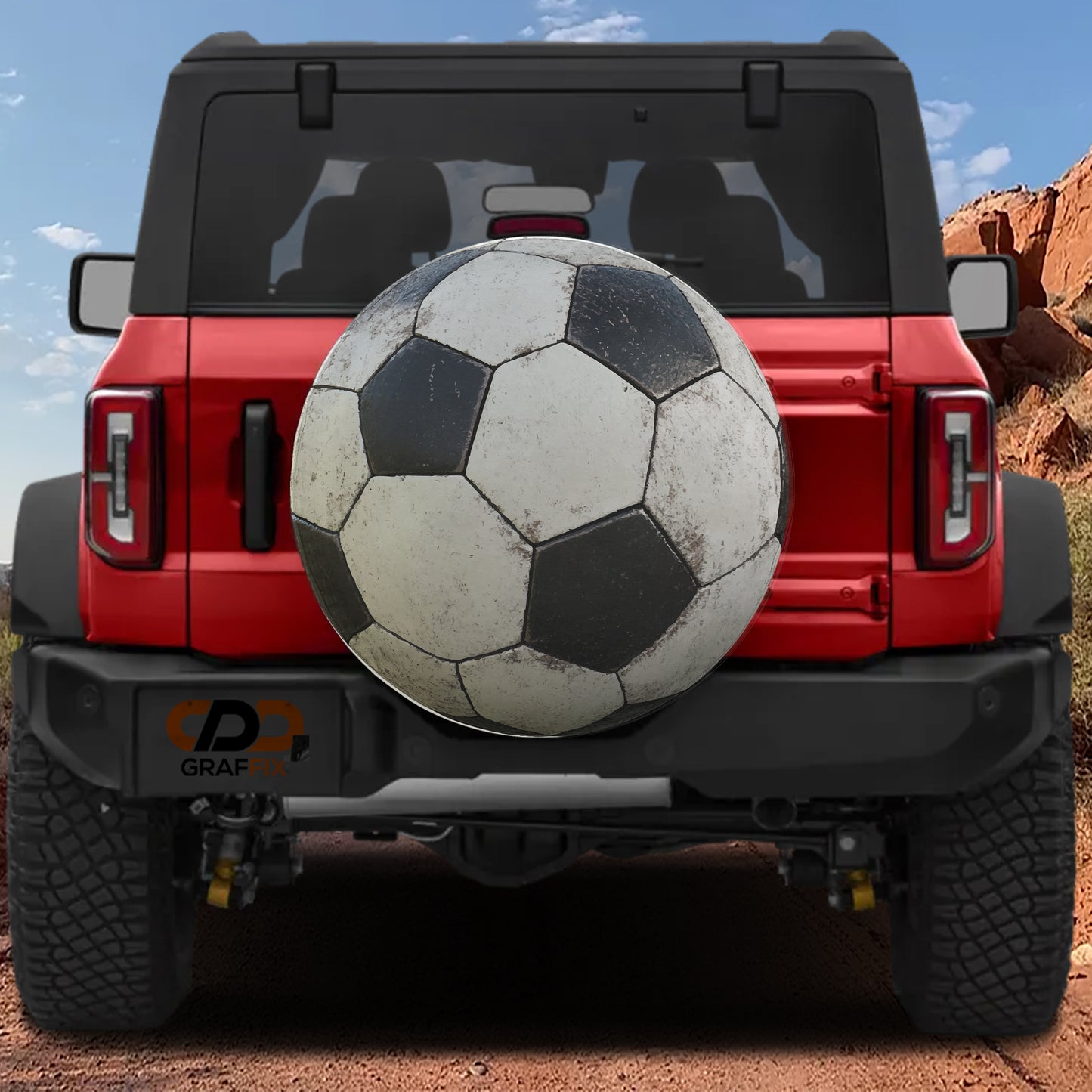 A red Jeep Wrangler with a soccer ball mounted on the rear bumper.