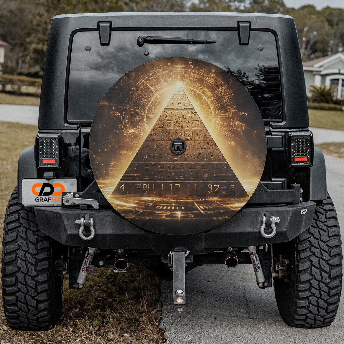 the back of a black Jeep Wrangler with a large, circular decal on the rear window depicting an ancient Egyptian pyramid.