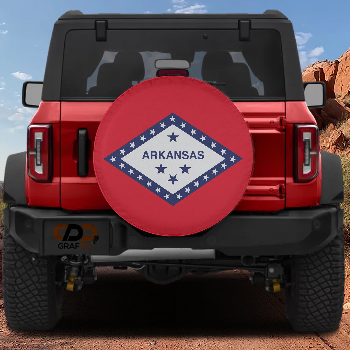 A red Jeep Wrangler with a large red and white tire cover on the rear of the vehicle, displaying the word "ARKANSAS" in the center.