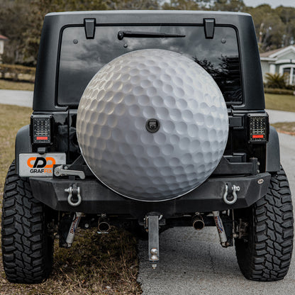 a black Jeep Wrangler with a large silver golf ball mounted on the rear bumper.