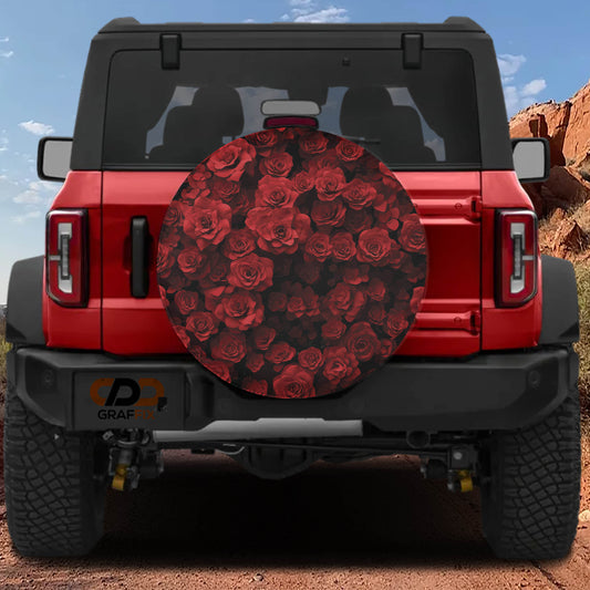 A red Jeep Wrangler with a large rose-patterned spare tire attached to the rear.