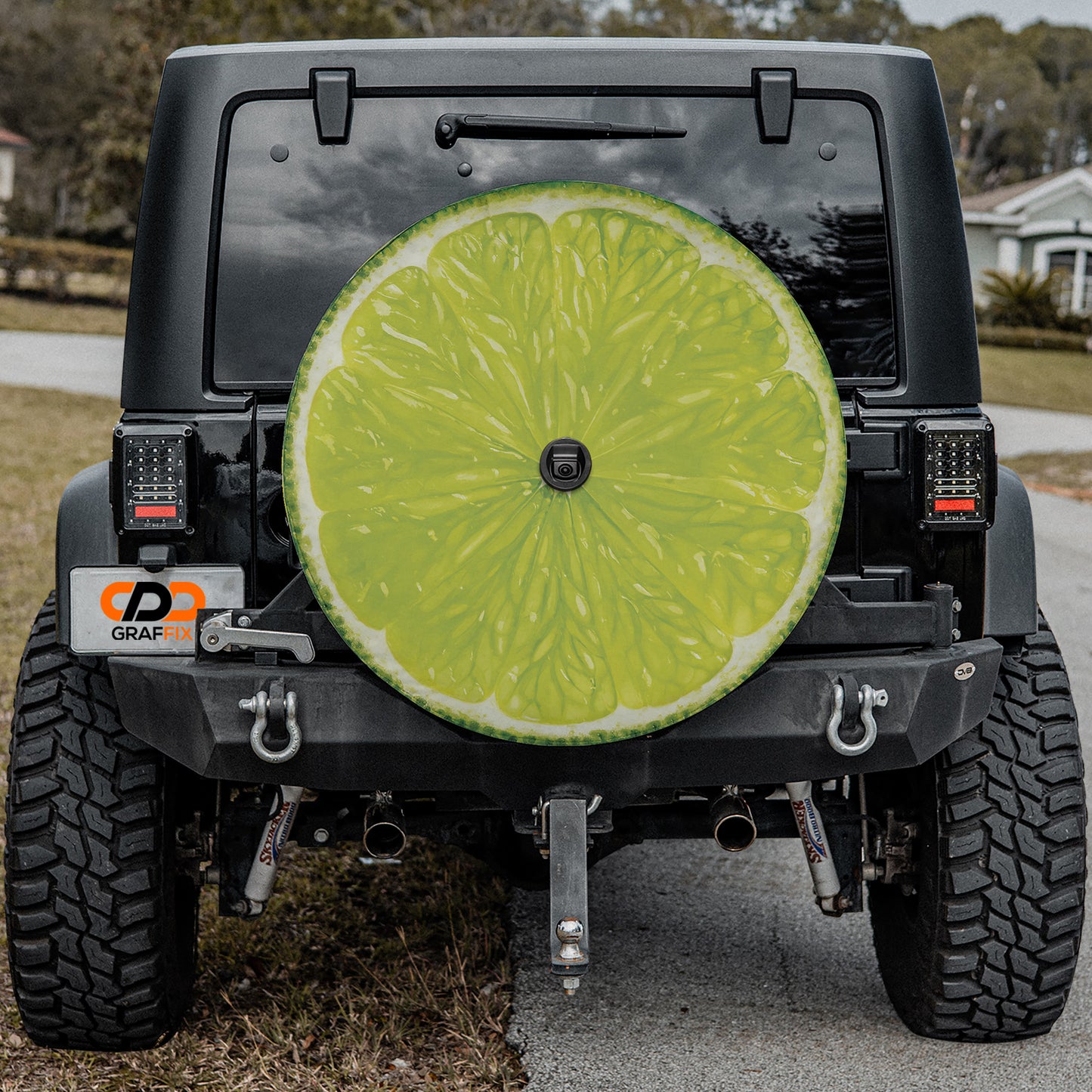 a black Jeep Wrangler with a large lime slice sticker on the rear window.