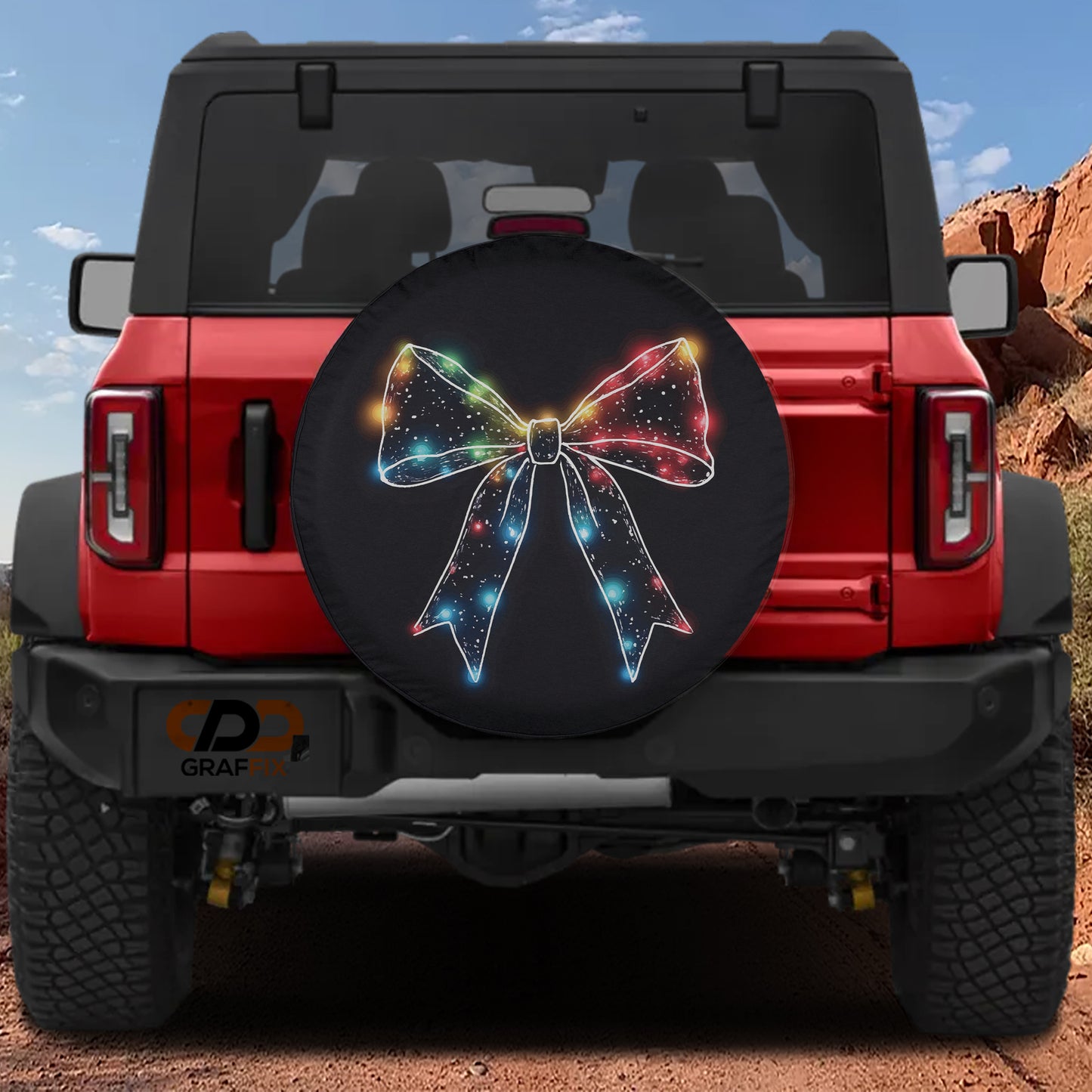 the rear of a red Jeep Wrangler with a large, colorful, illuminated bow-shaped spare tire cover attached to the vehicle.
