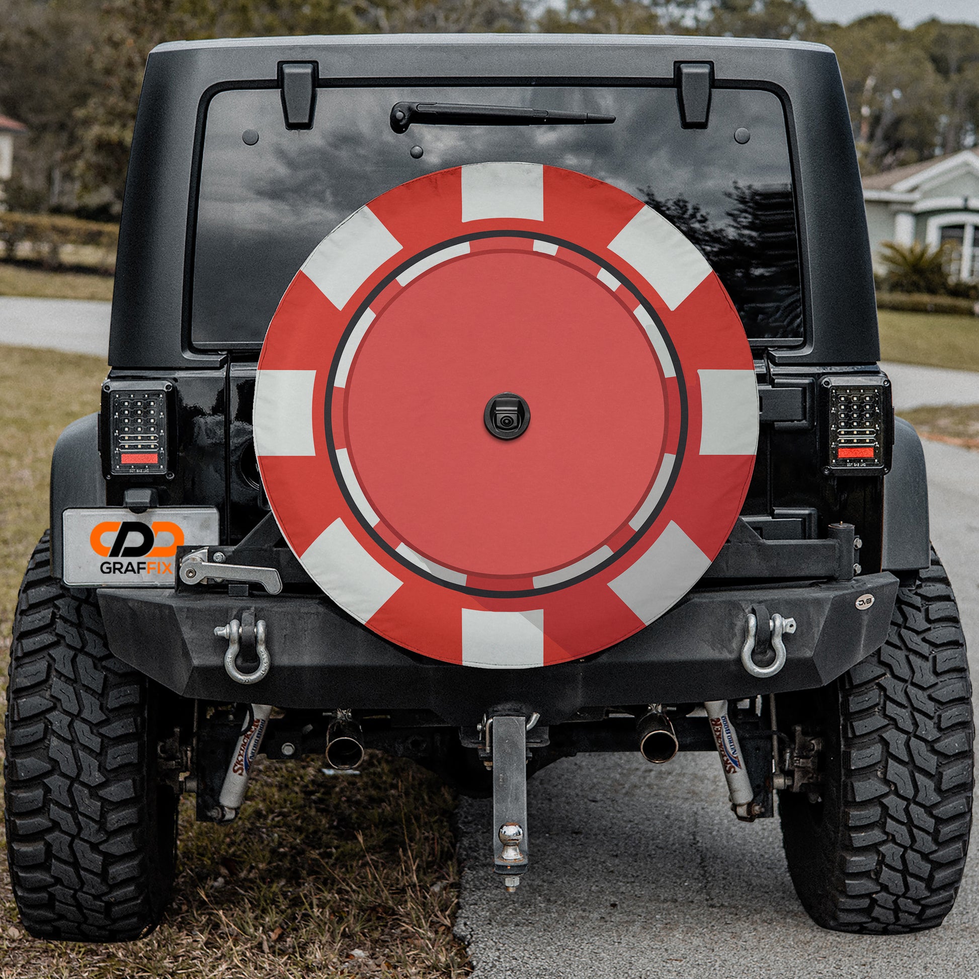 the rear of a black Jeep Wrangler with a large red and white tire cover attached to the vehicle.