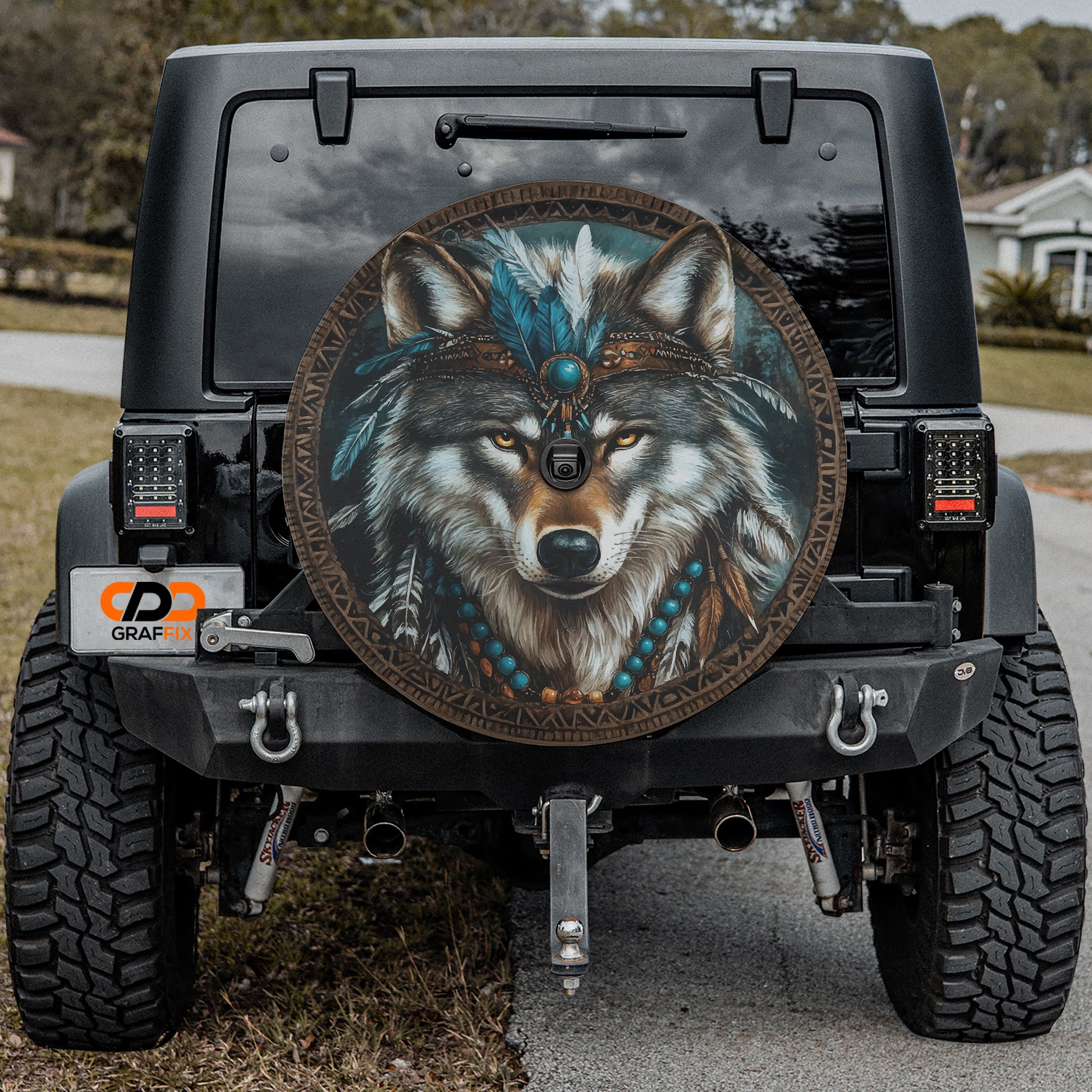 a black Jeep Wrangler with a large tribal-style decal on the rear window.