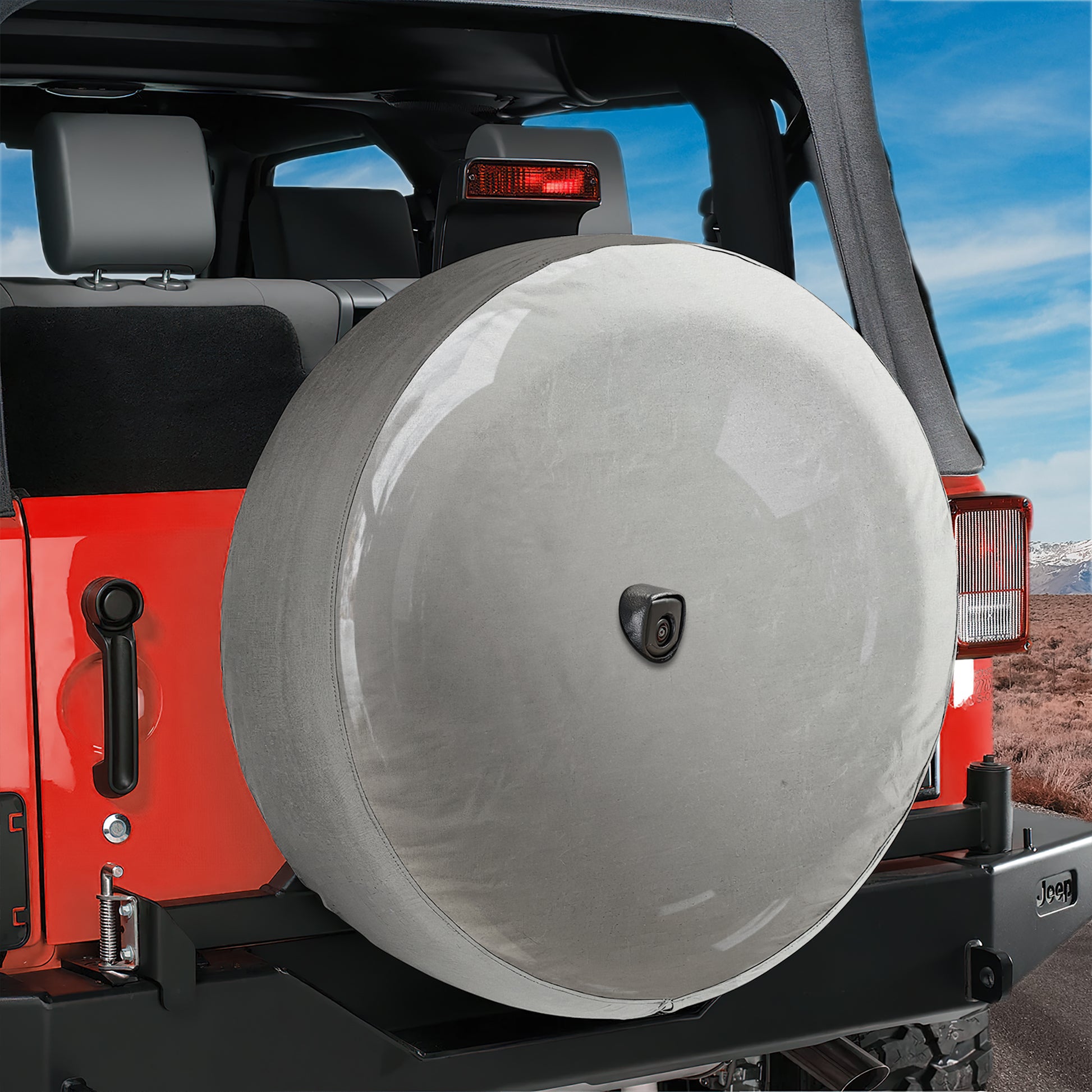 A red Jeep Wrangler with a spare tire mounted on the rear of the vehicle.