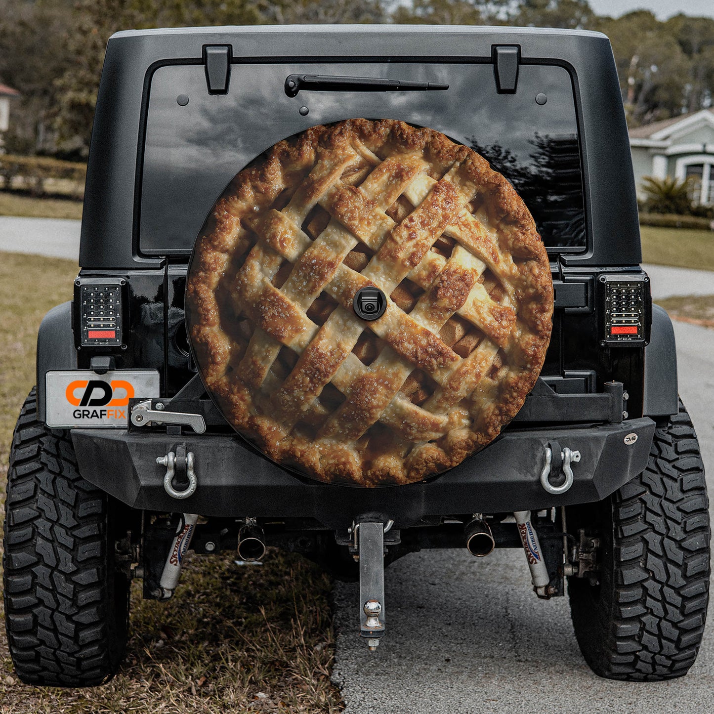 a black Jeep Wrangler with a pie-shaped cover on the rear window, which appears to be a custom design or decoration.