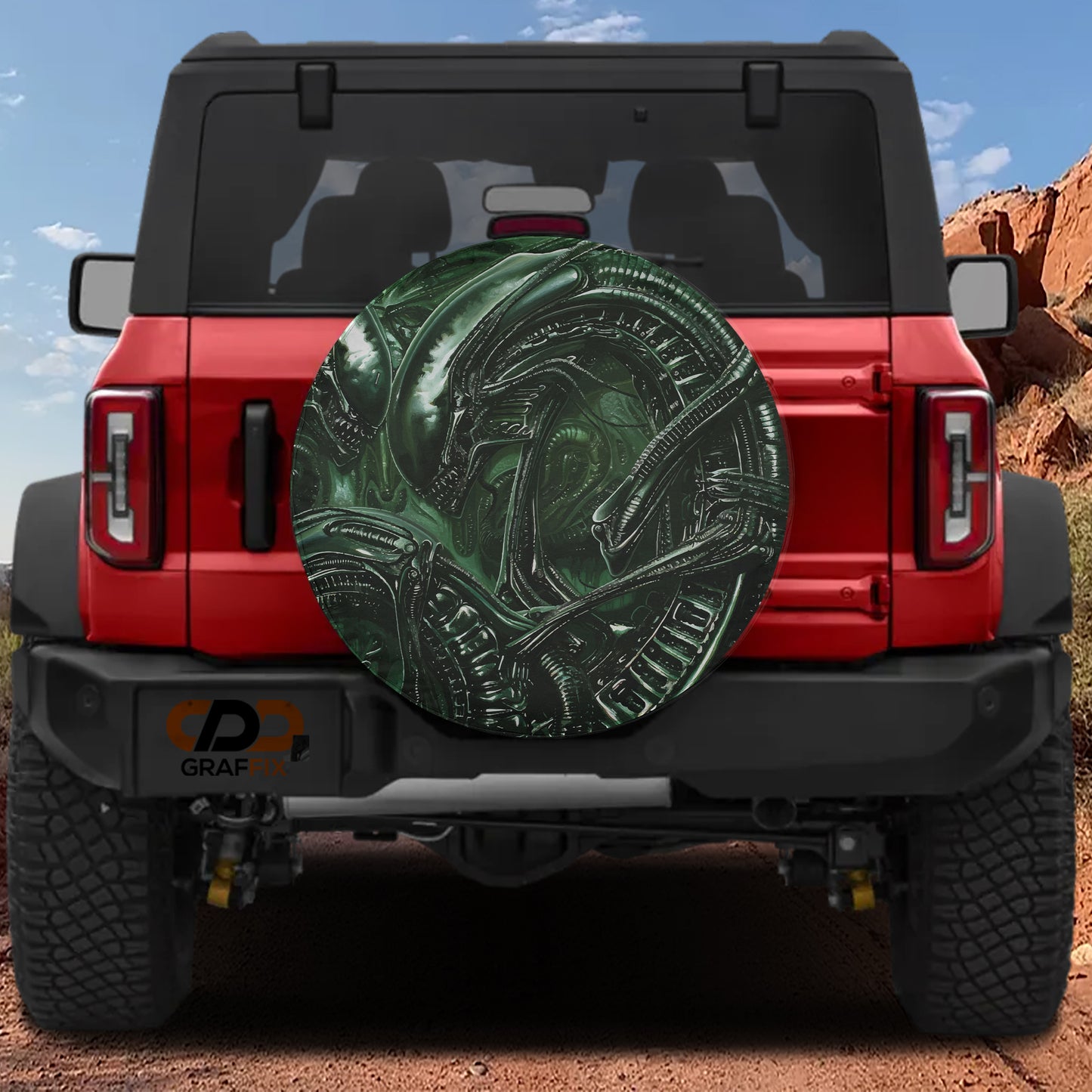 the rear of a red Jeep Wrangler with a large green alien-like design on the rear window.