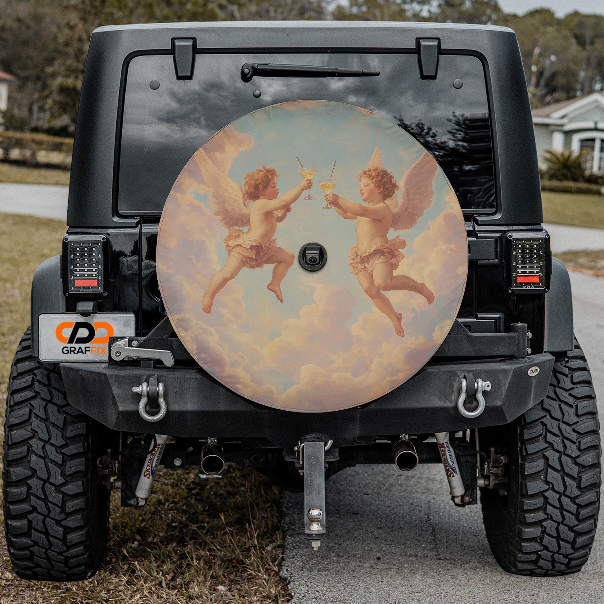 a black jeep with a large, circular spare tire cover on the rear. The cover has a painting of cherubs holding drinks, giving the jeep a unique and artistic appearance.