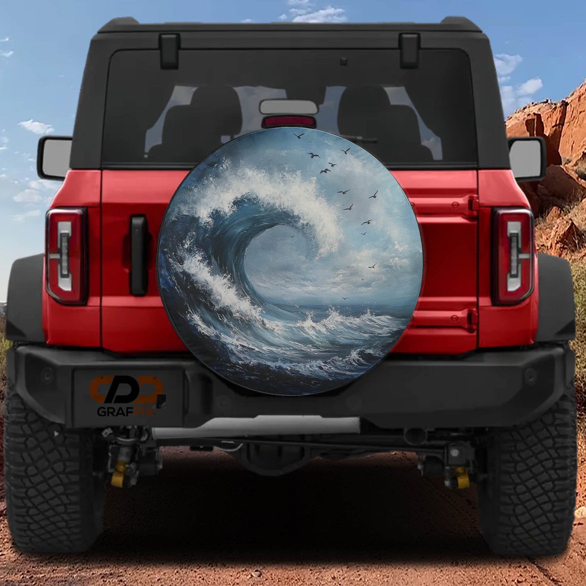 the rear of a red Jeep Wrangler with a large surf wheel cover depicting a crashing wave and birds in flight.