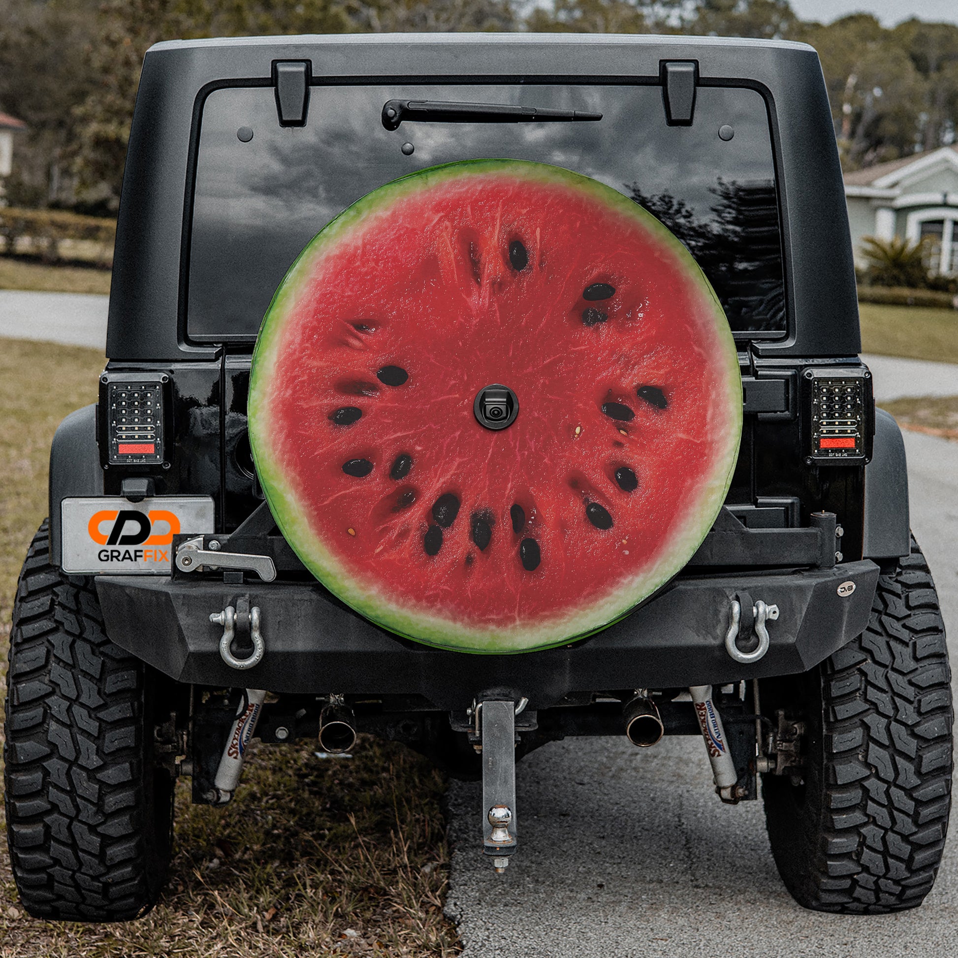 a black Jeep Wrangler with a large watermelon sticker on the rear window.