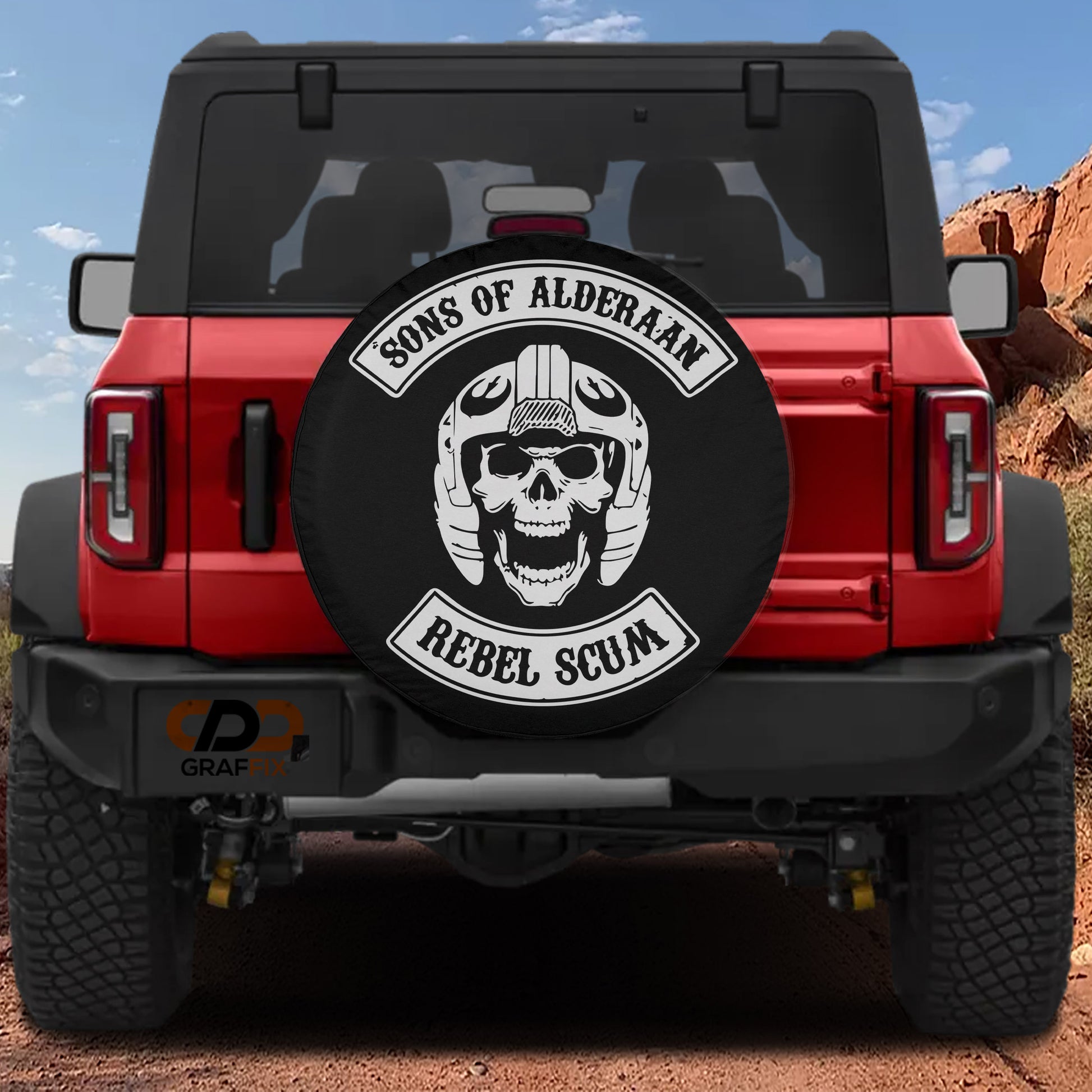 the back of a red Jeep Wrangler with a black and white skull-themed spare tire cover.