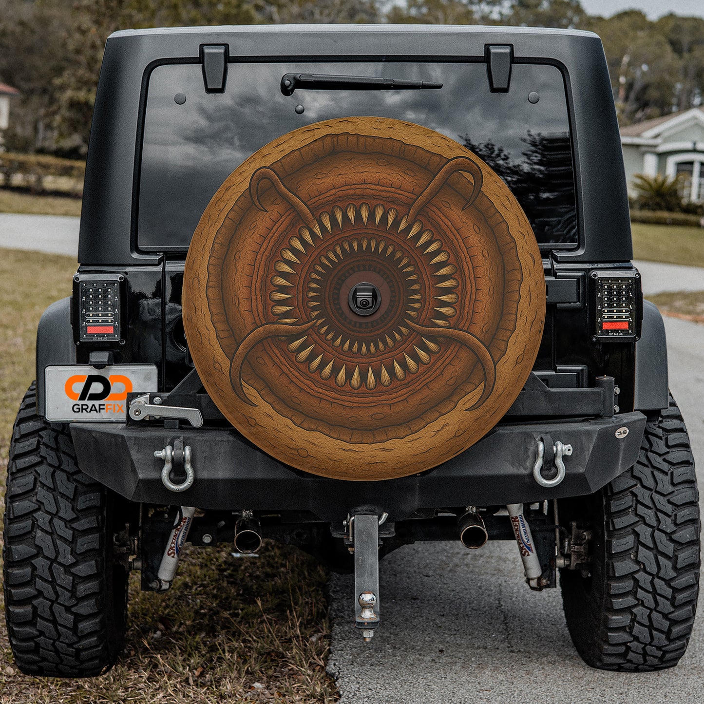 the rear of a black Jeep Wrangler with a large, decorative wheel cover attached to the vehicle.