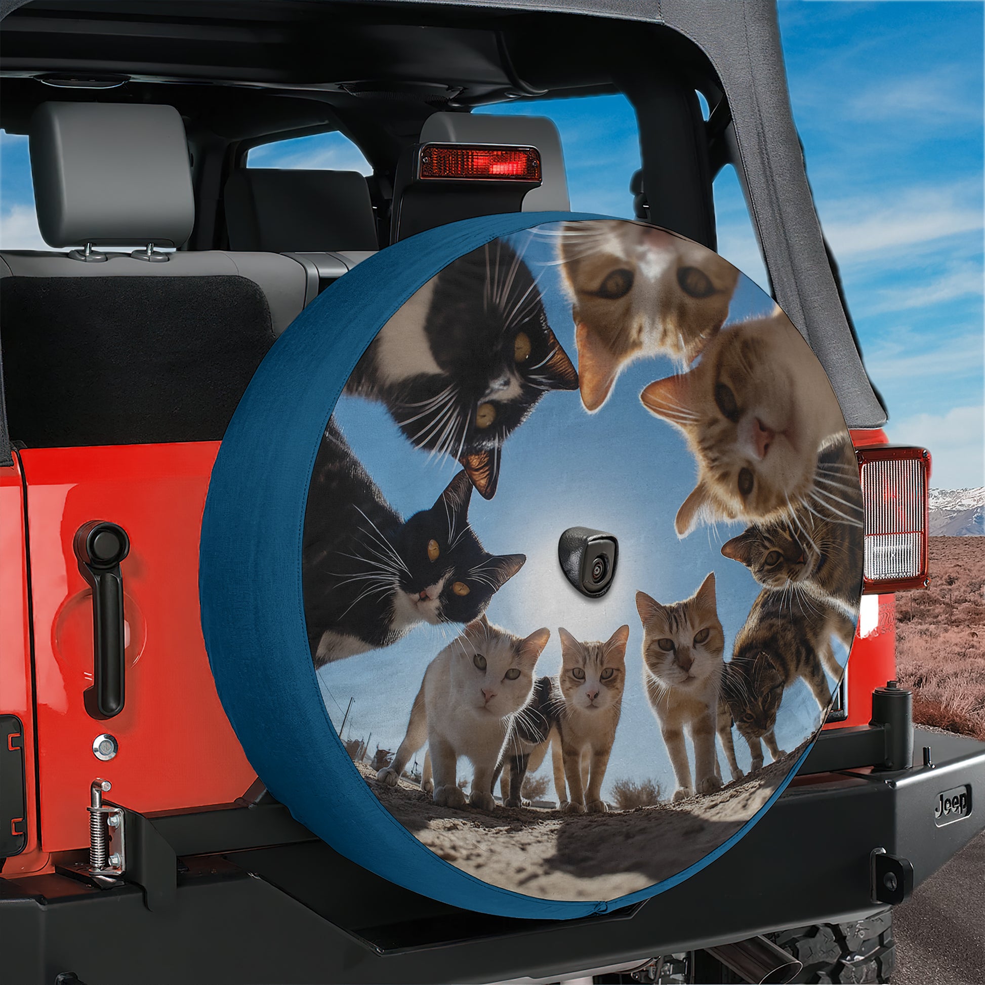 A large, round spare tire cover on a Jeep vehicle, featuring a collage of multiple cat images arranged in a circular pattern.