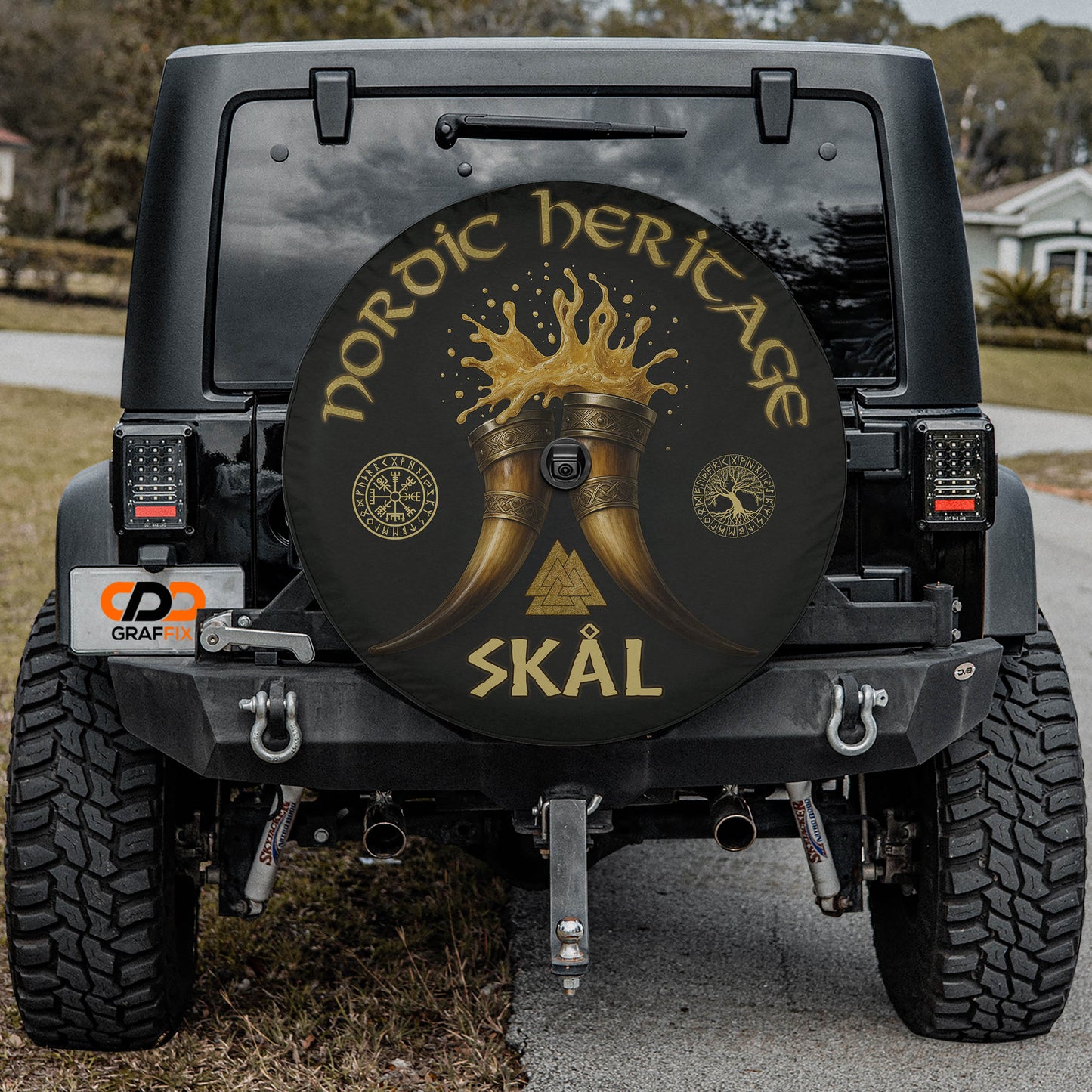 the back of a black Jeep Wrangler with a large black tire cover featuring a golden design and text.