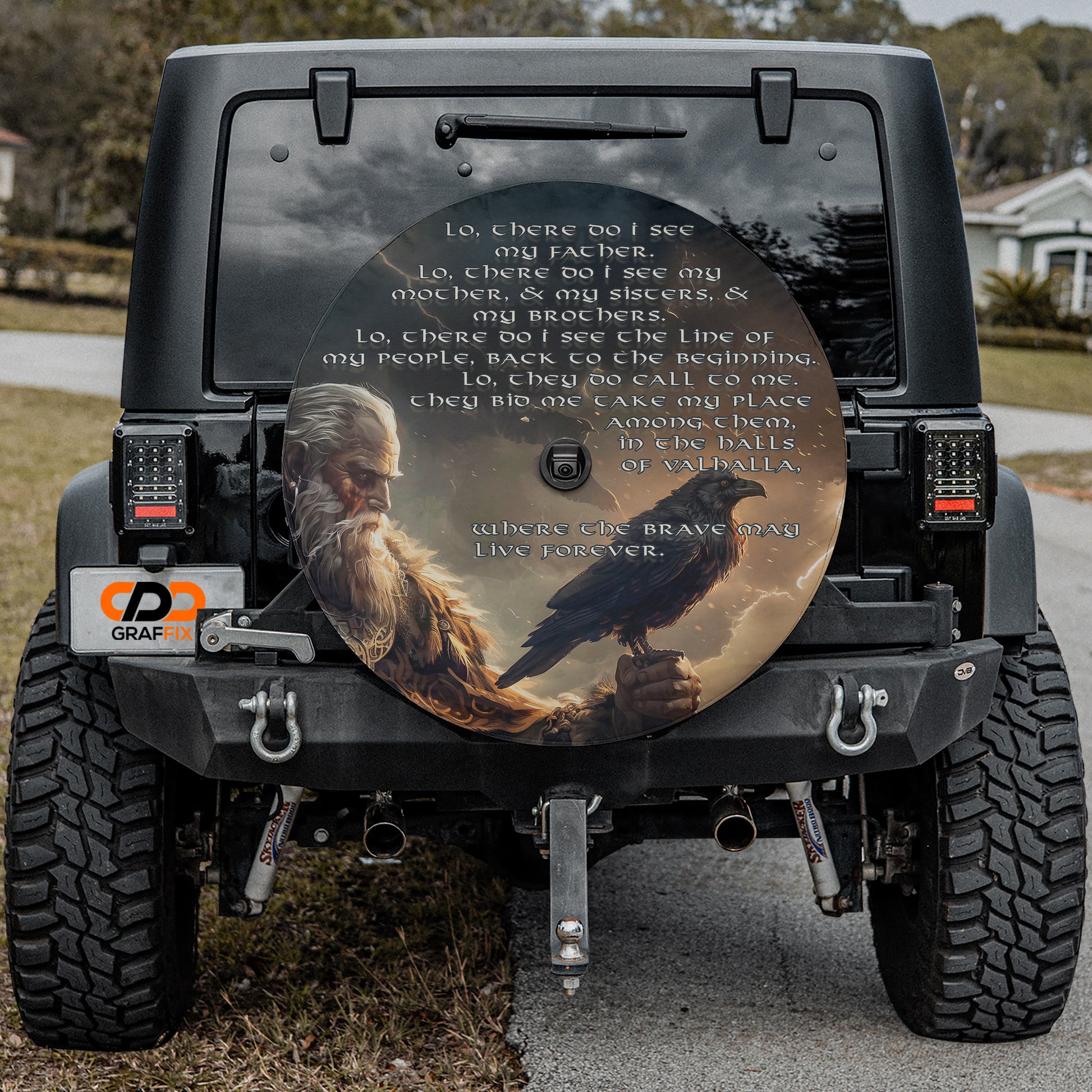 a black Jeep Wrangler with a large, round decal on the rear window depicting a bearded man and a black bird.