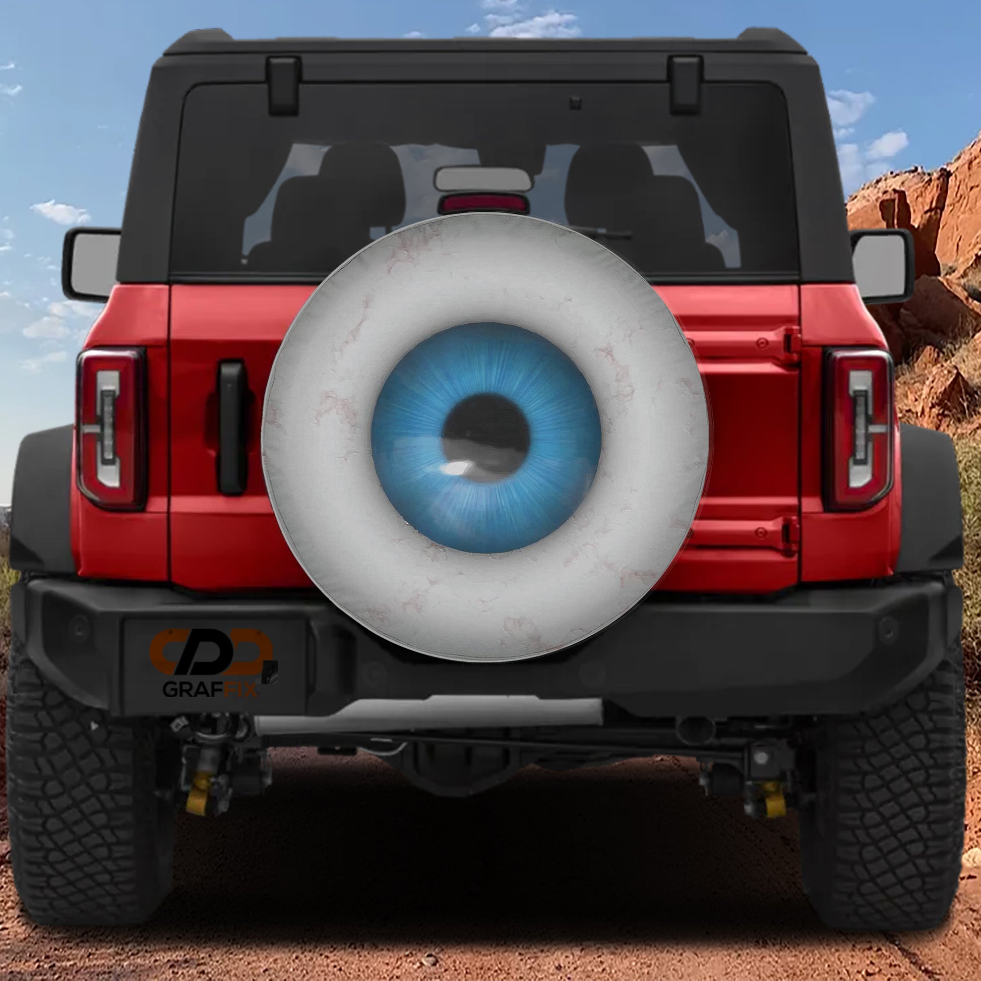 A red Jeep Wrangler with a large eye decal on the rear window.