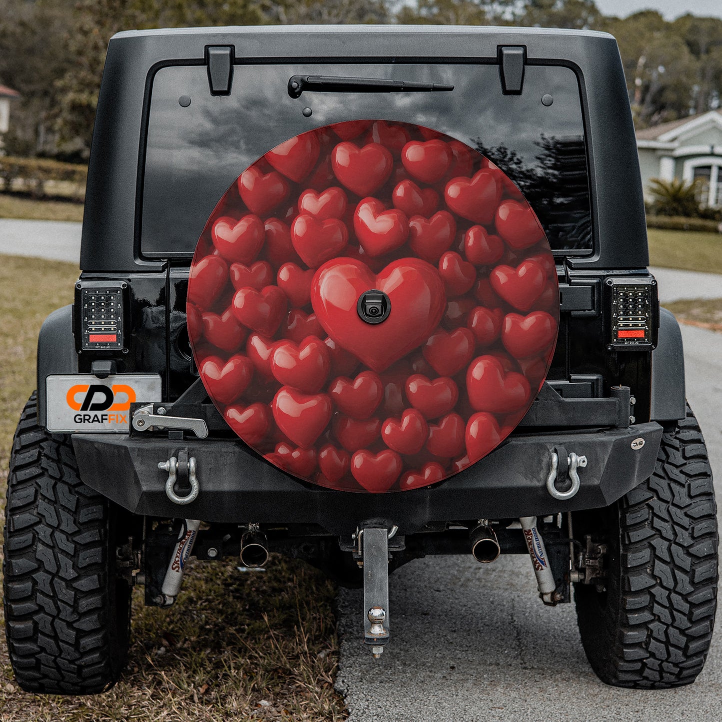 the back of a black Jeep Wrangler with a large heart-shaped spare tire attached to it.