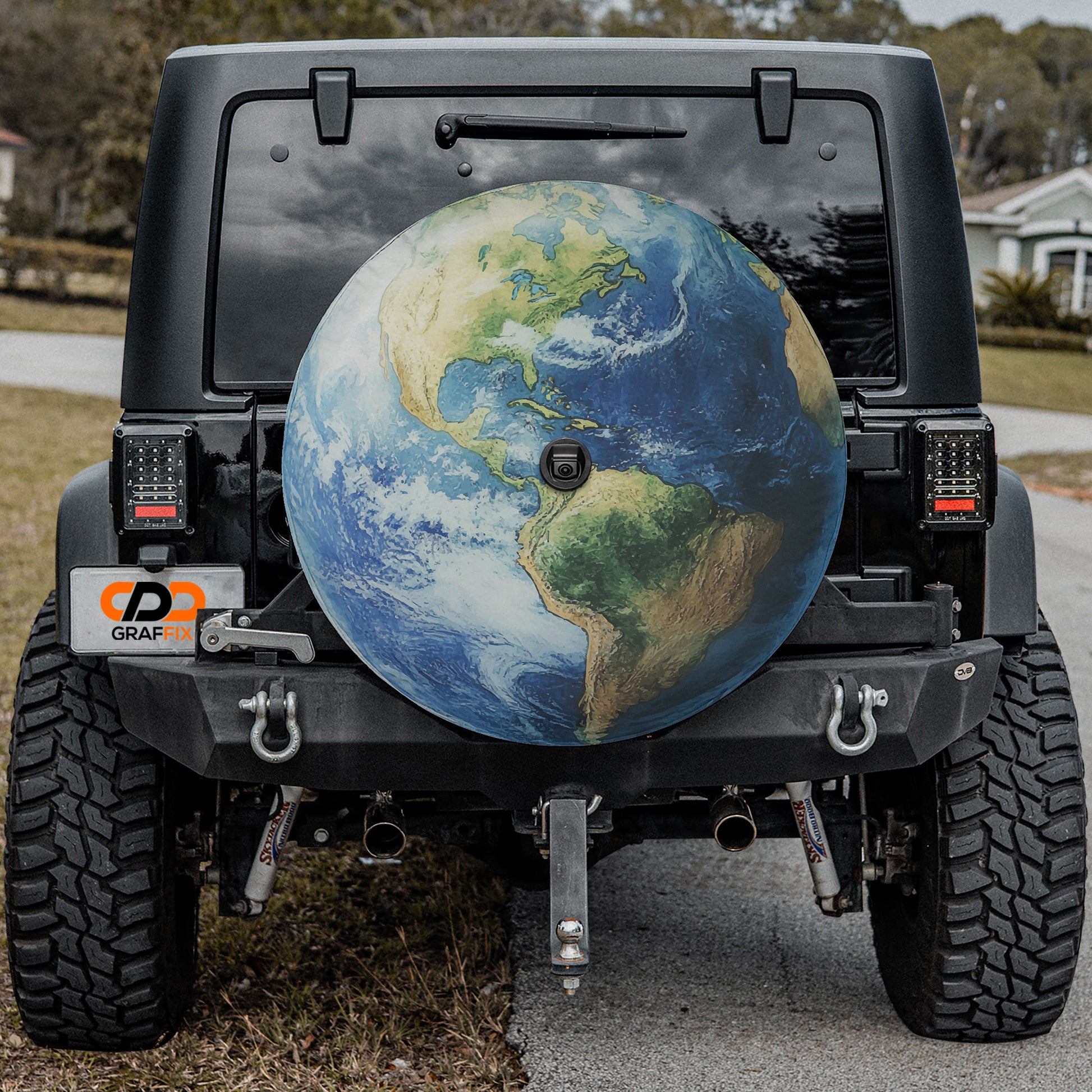 a black Jeep Wrangler with a large globe-shaped spare tire attached to the rear of the vehicle.
