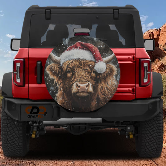 A red Jeep Wrangler with a large, round spare tire cover featuring a picture of a Highland cow wearing a Santa hat.