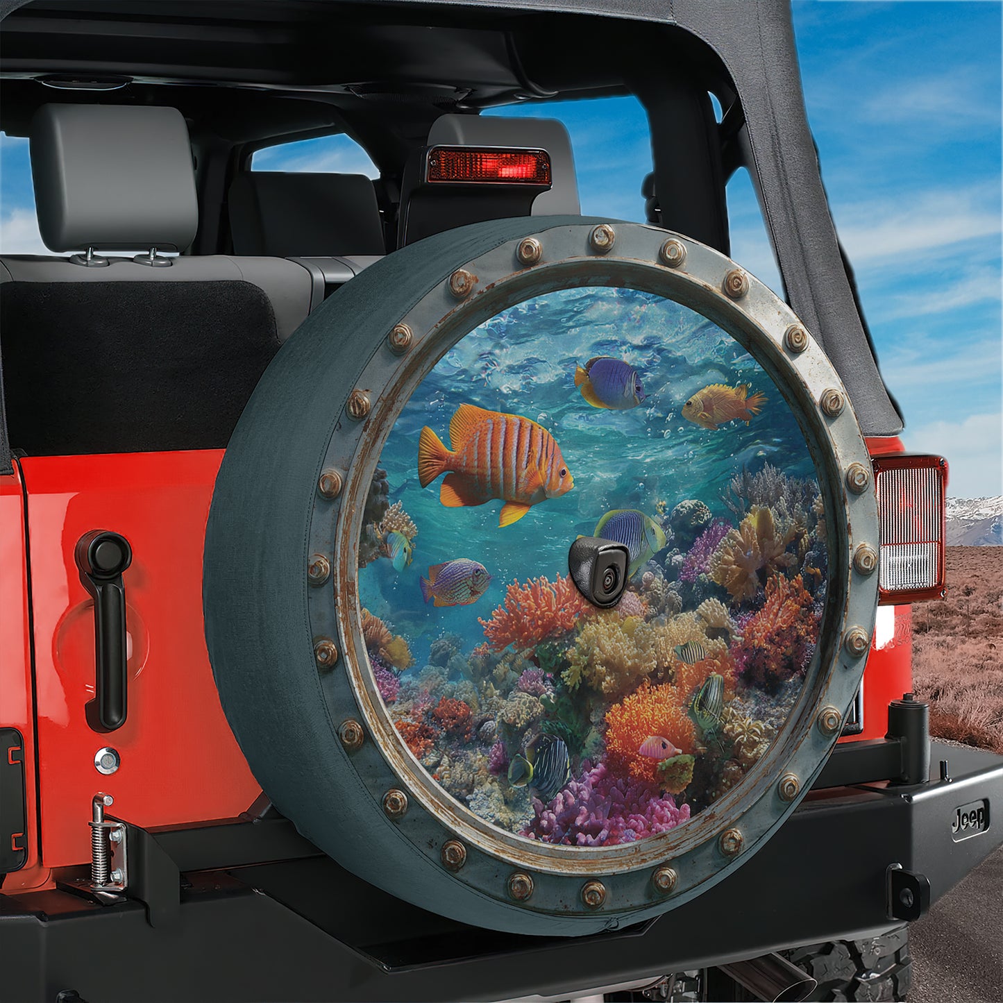 A Jeep vehicle with a large, round spare tire cover that features a vibrant underwater scene with colorful fish swimming among coral and other marine life.