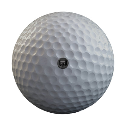 A close-up view of a white golf ball with a small camera attached to it.