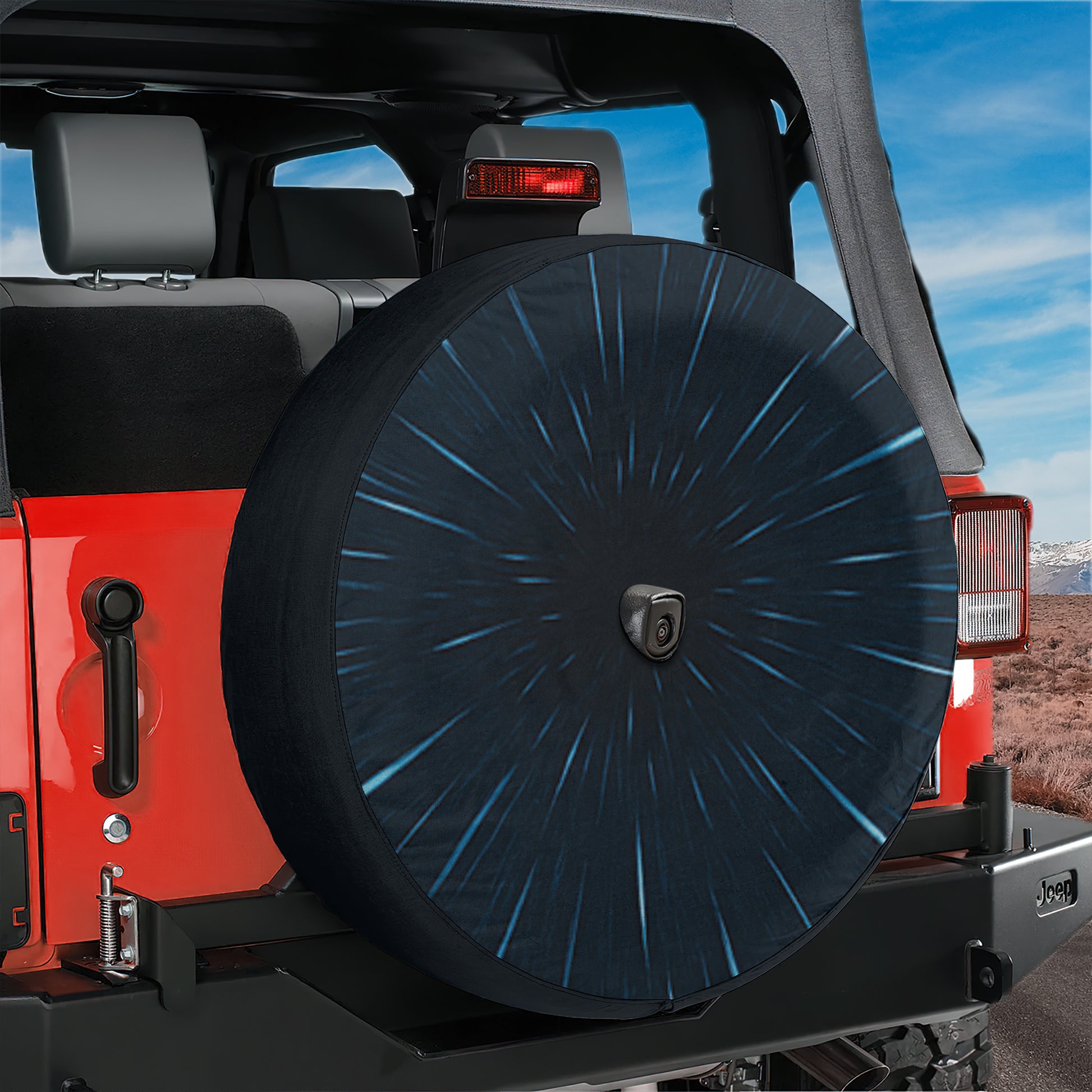 A red Jeep with a black tire cover featuring a Star Wars design is parked in a desert-like environment.
