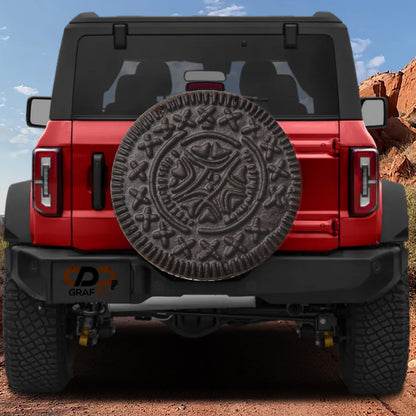 a red Jeep Wrangler with a large, decorative tire cover attached to the rear of the vehicle.