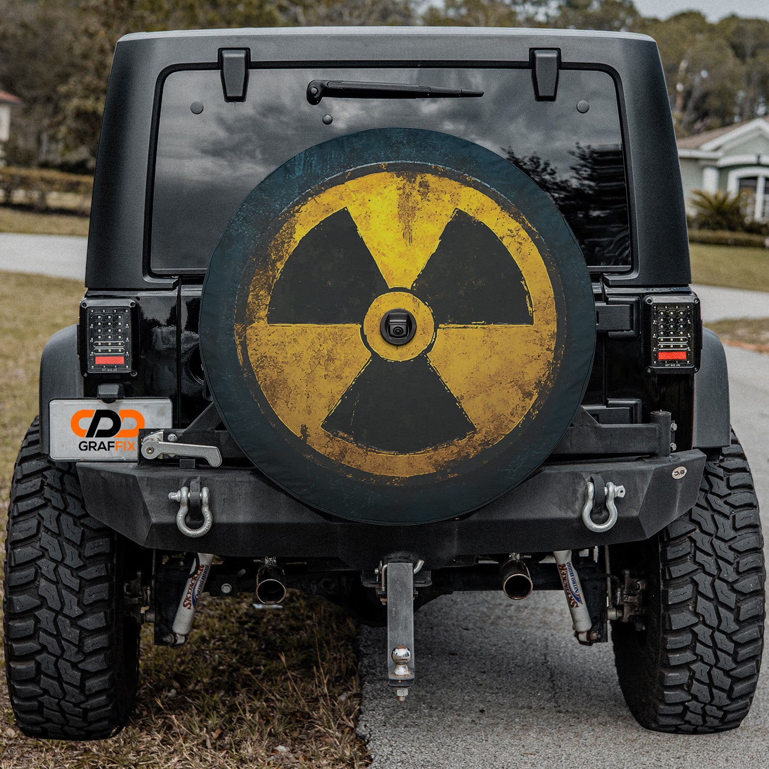 a yellow and black radioactive sign on the back of a black jeep