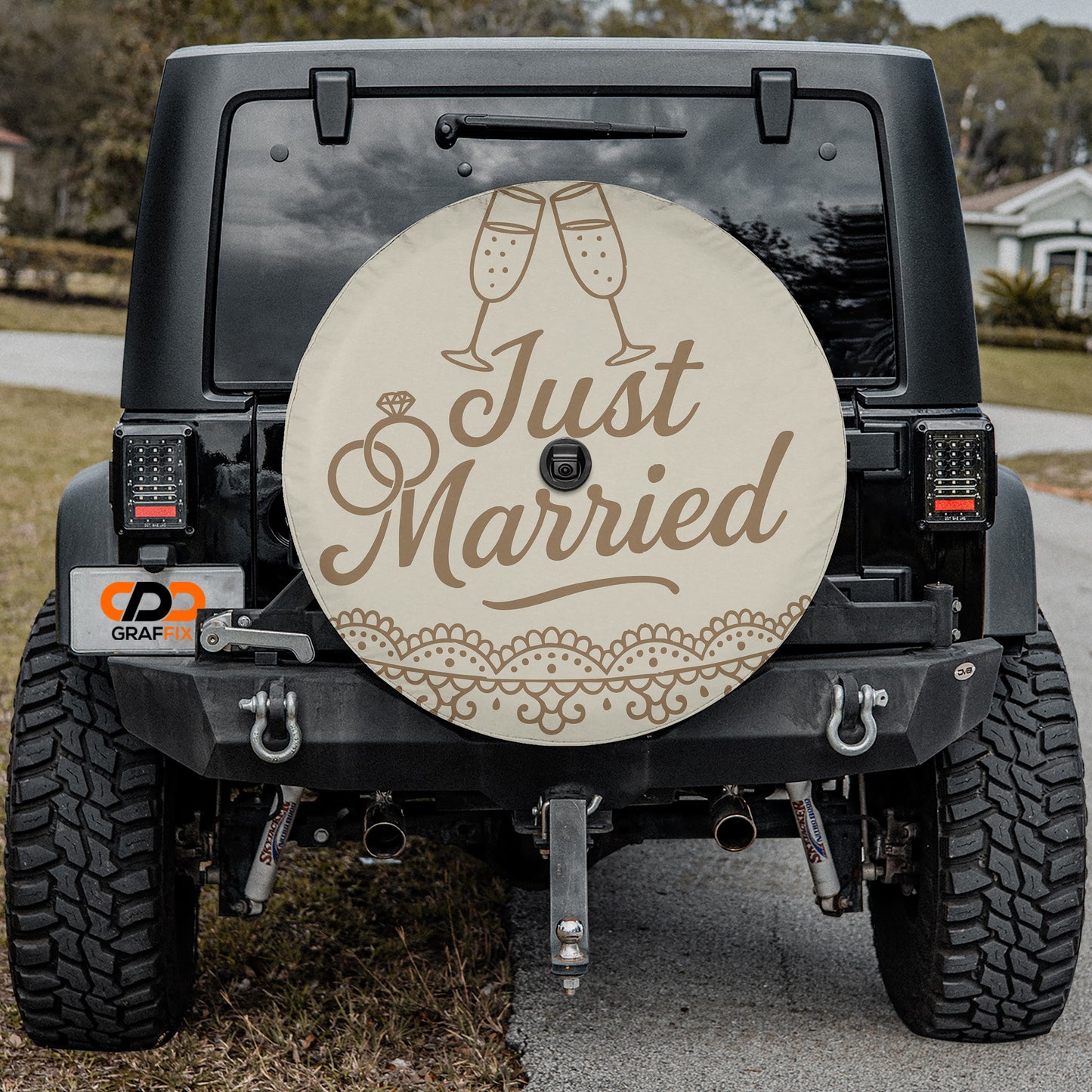 the back of a black jeep with a decorative license plate and a spare tire cover featuring the text "Just Married" and a champagne glass icon.