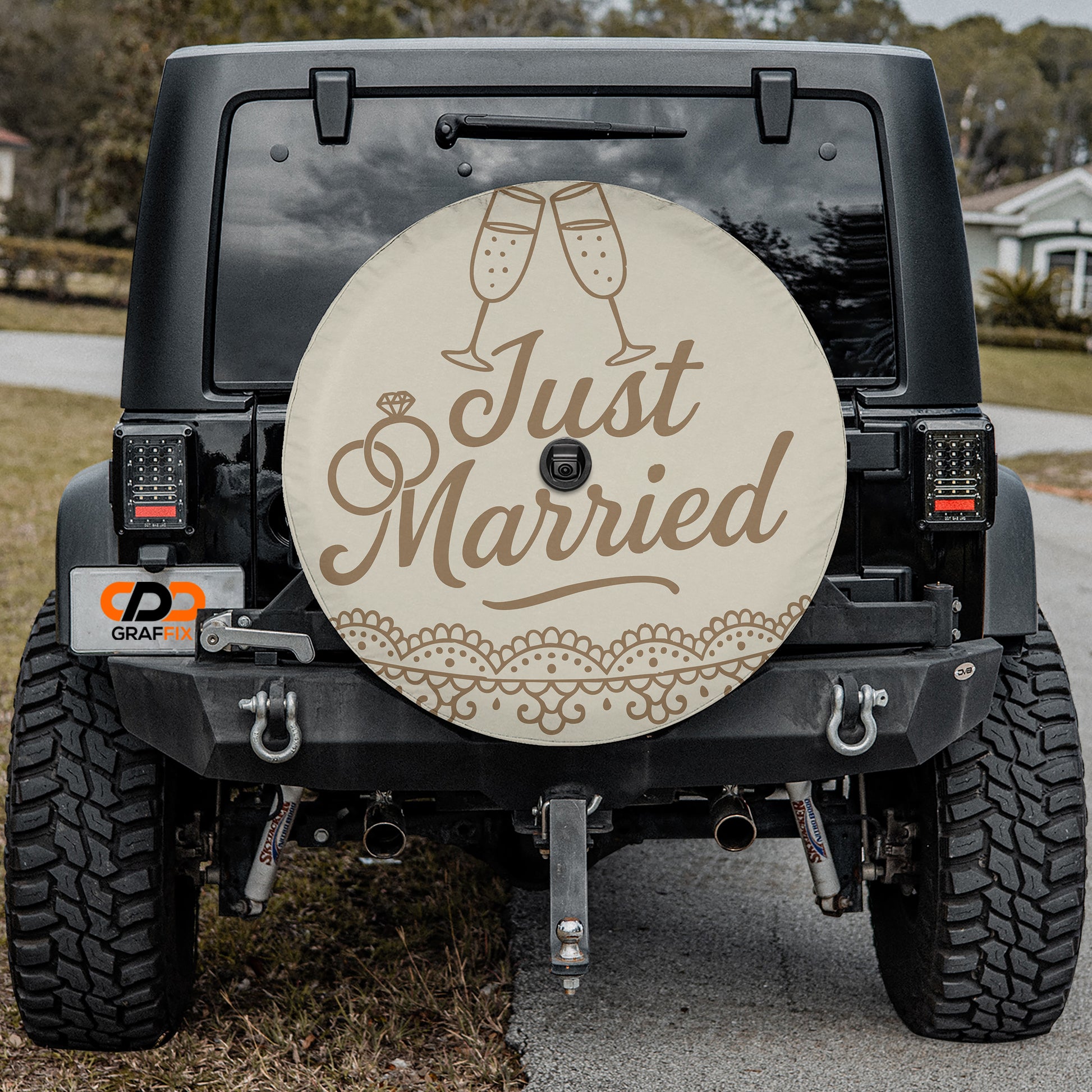 the back of a black jeep with a decorative license plate and a spare tire cover featuring the text "Just Married" and a champagne glass icon.