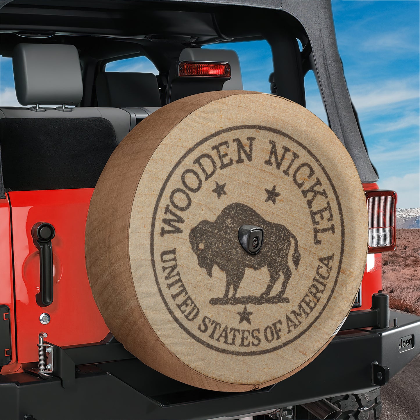 A red Jeep Wrangler with a wooden spare tire attached, featuring a circular emblem with the text "WOODEN NICKEL" and "UNITED STATES OF AMERICA".