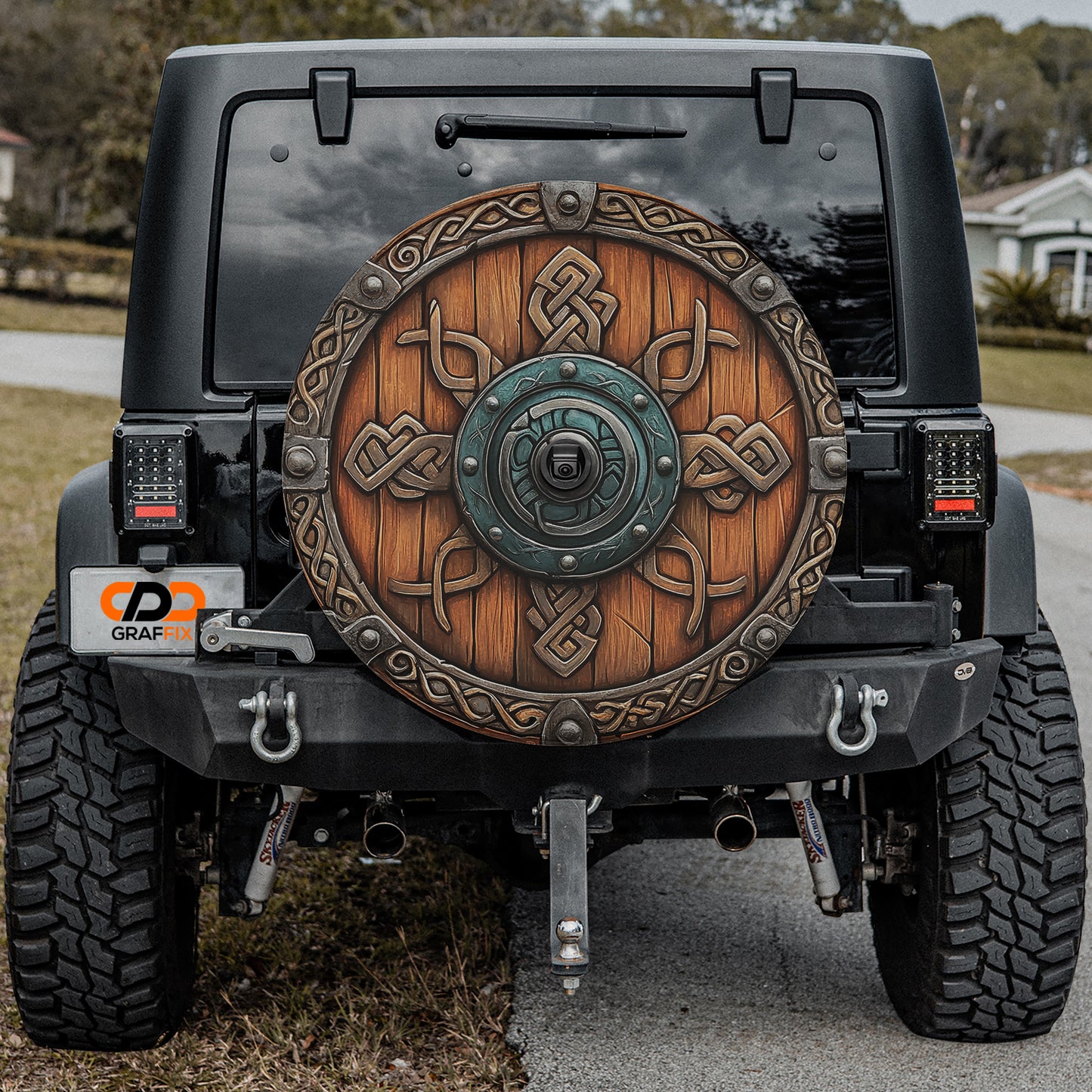 a black Jeep Wrangler with a large wooden shield-like decoration on the rear of the vehicle.