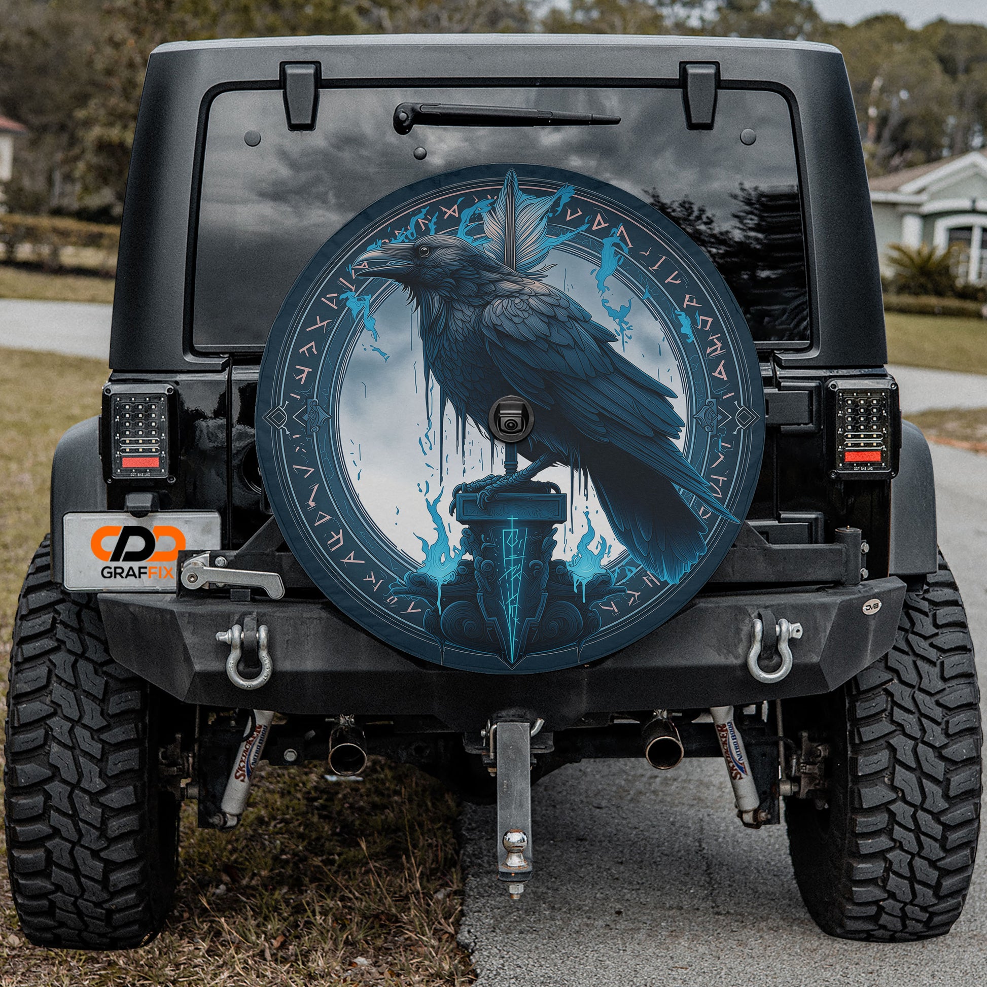 the rear of a black Jeep Wrangler with a large, circular decal featuring a black bird on a blue background.
